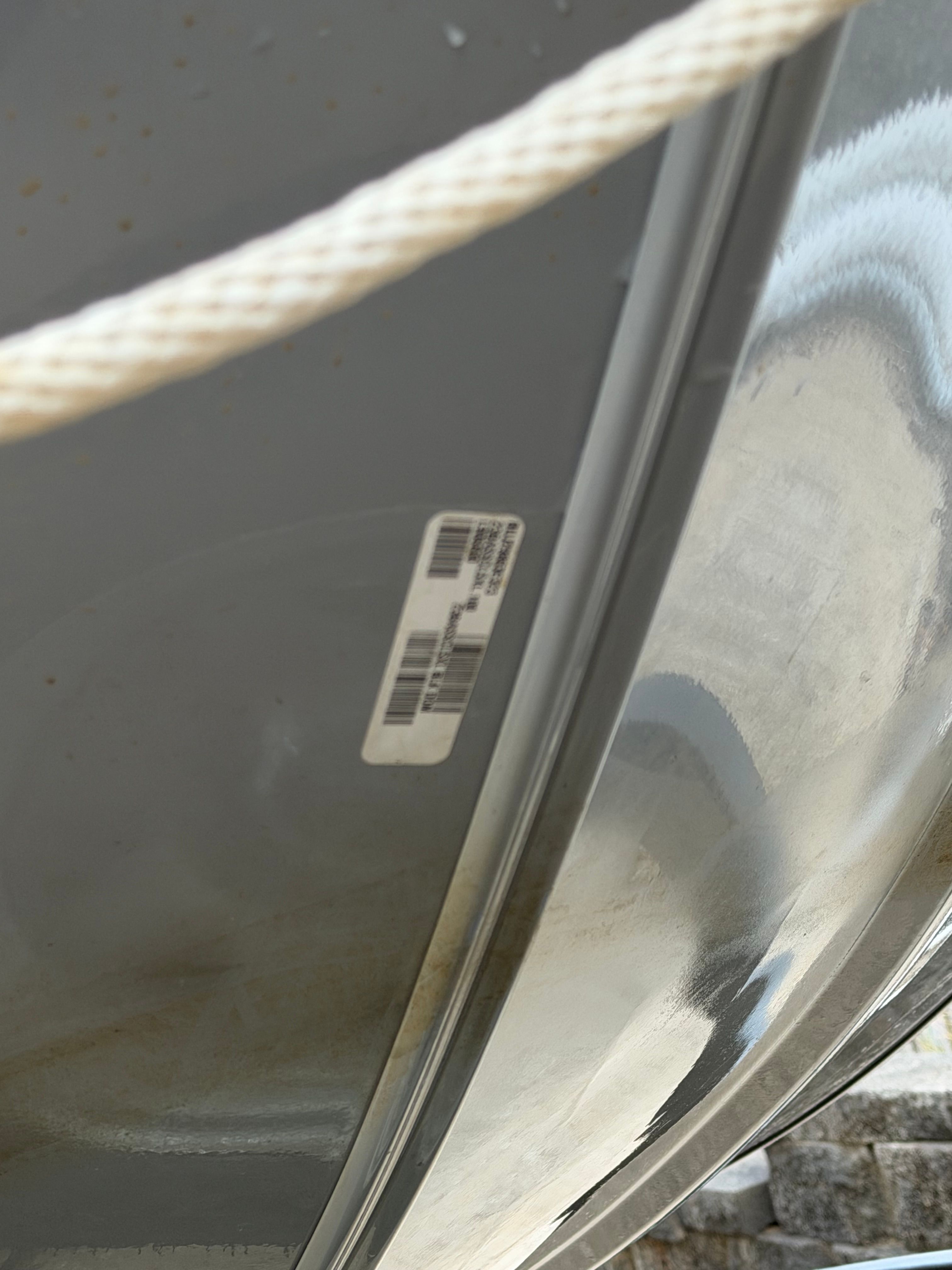 Close-up of a boat with a barcode sticker on its side.