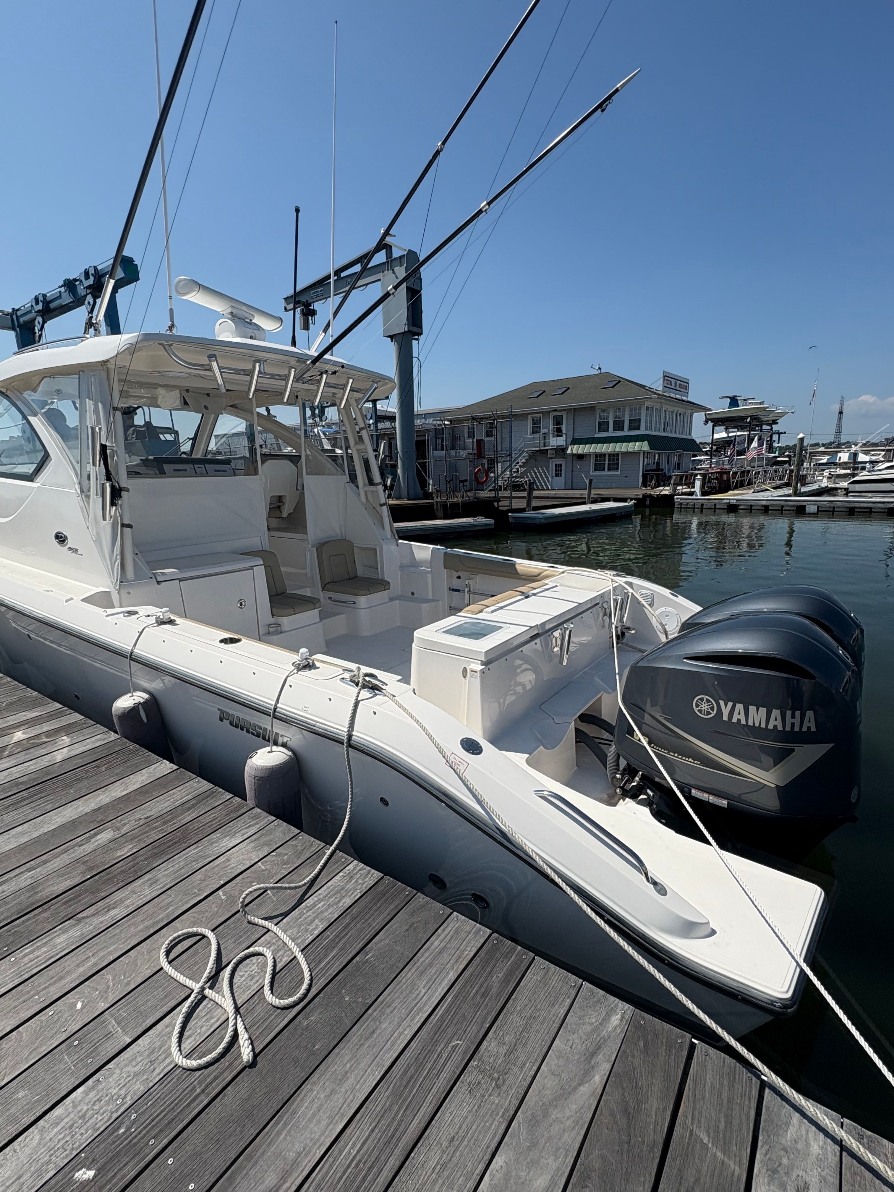 2017 Pursuit OS 355 Offshore boat docked with Yamaha engines, marina background.