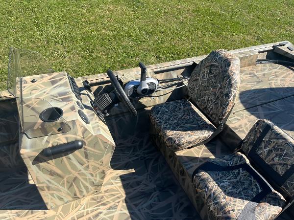 2025 Lowe Roughneck 2070 SC boat with camouflage seats and steering console.