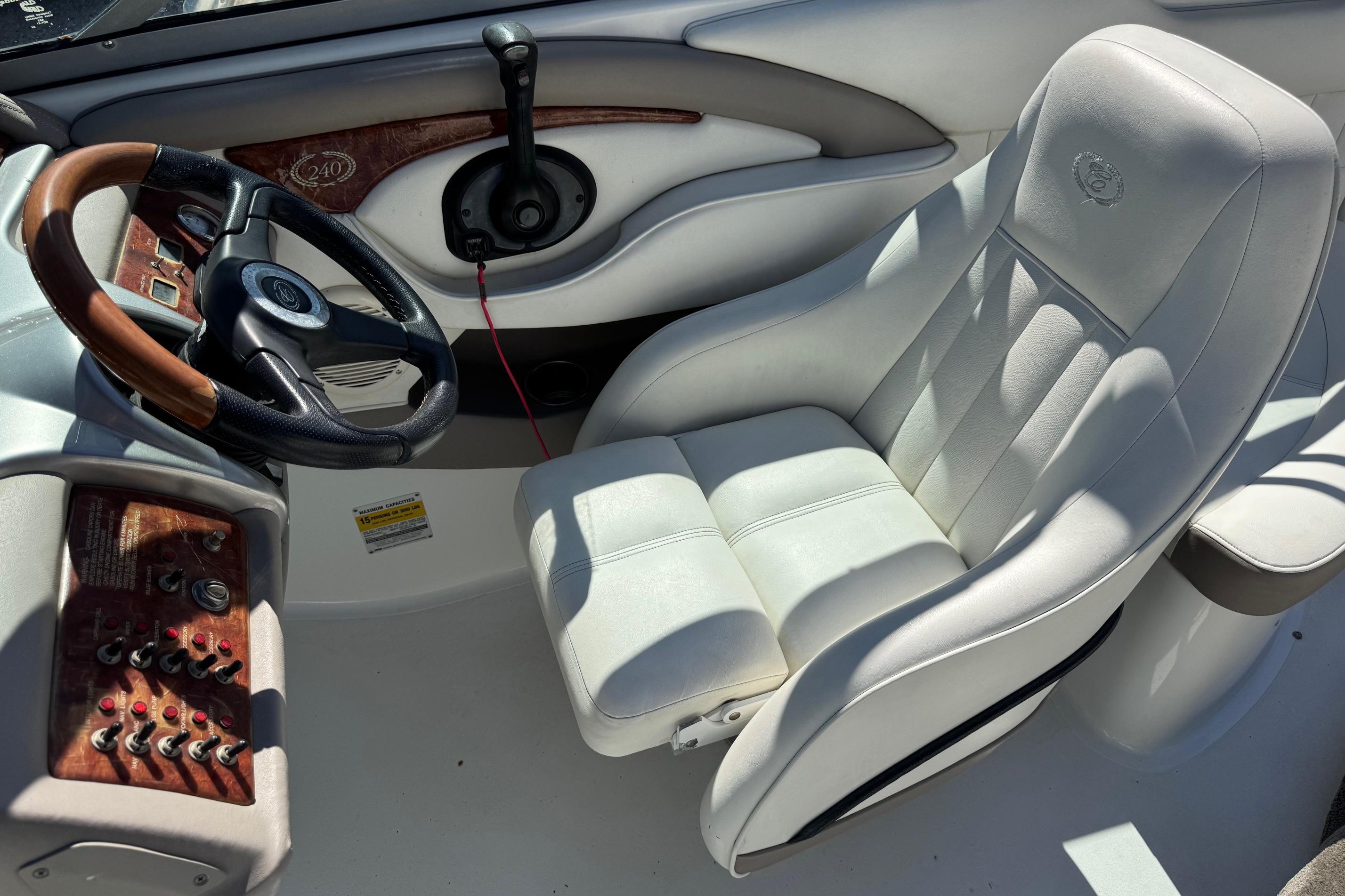 2005 Cobalt 240 boat interior with white leather seat and wooden dashboard.