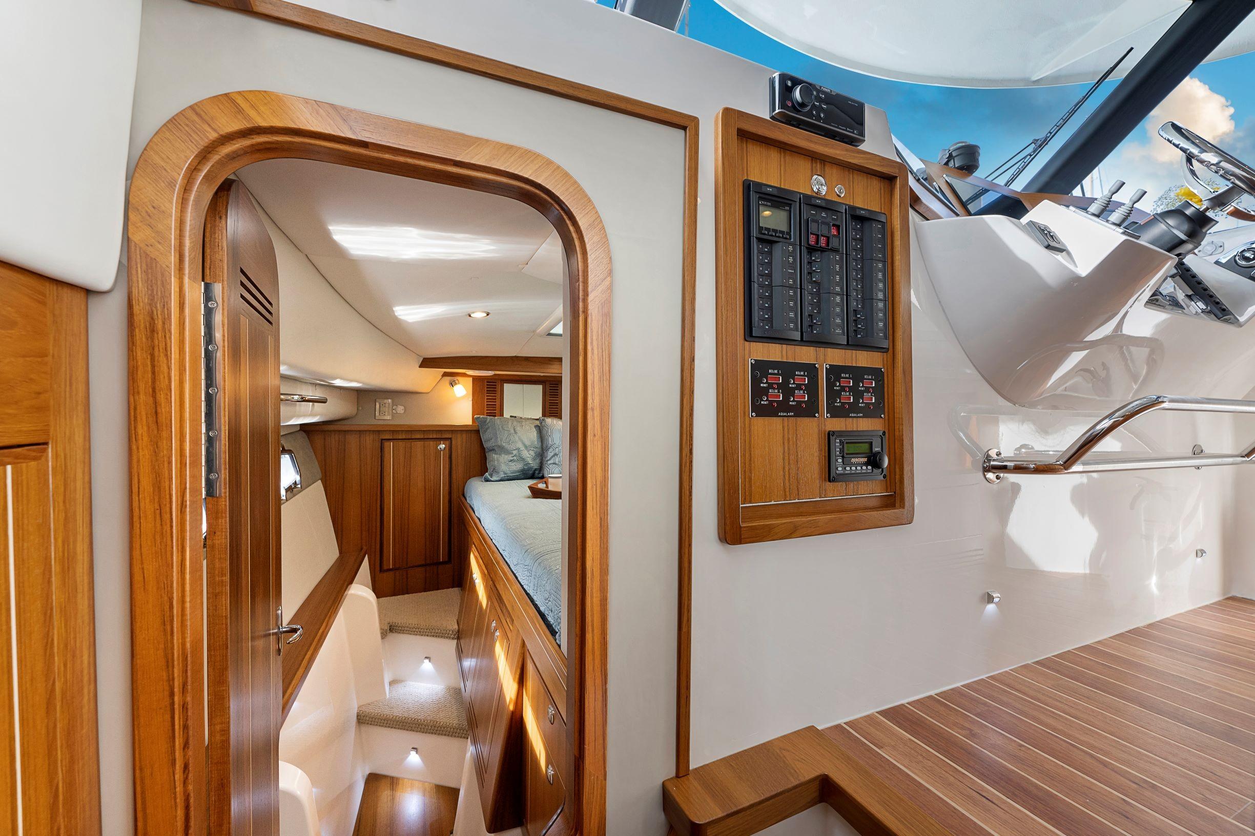 Interior of 2026 Aspen C128 Flybridge yacht with wood paneling and control panels.