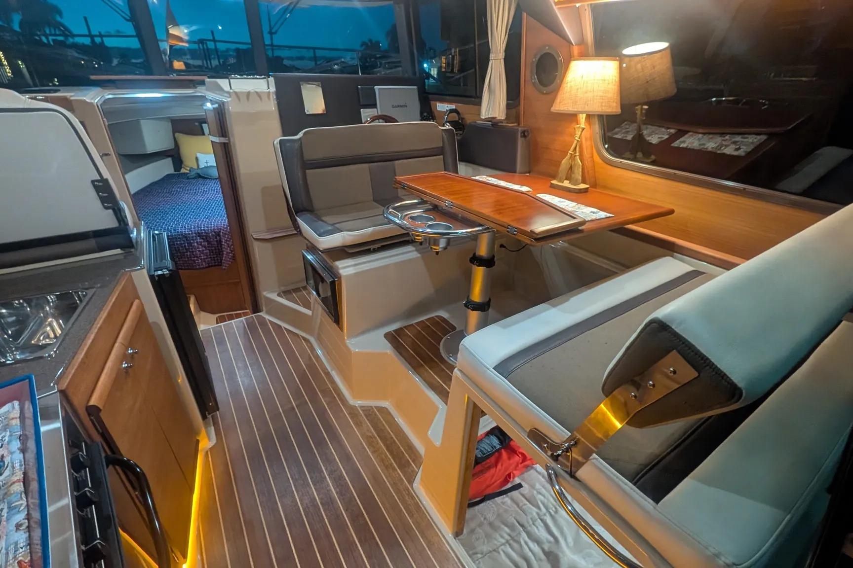 Interior of 2015 Ranger Tugs R-29 S boat with cozy seating and wooden table.