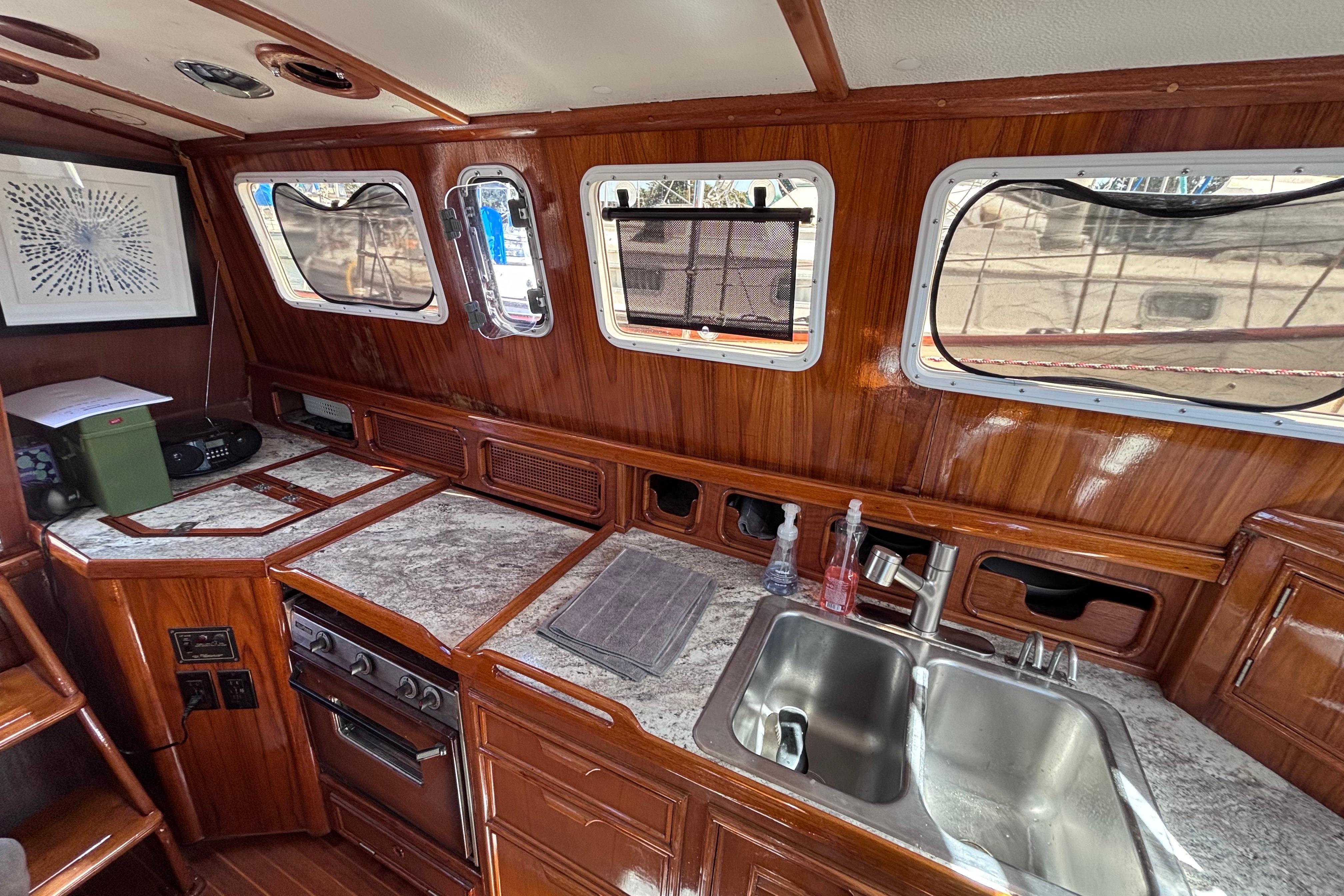 Interior of a 1978 Swift 33 boat featuring a wooden kitchen with a sink and stove.