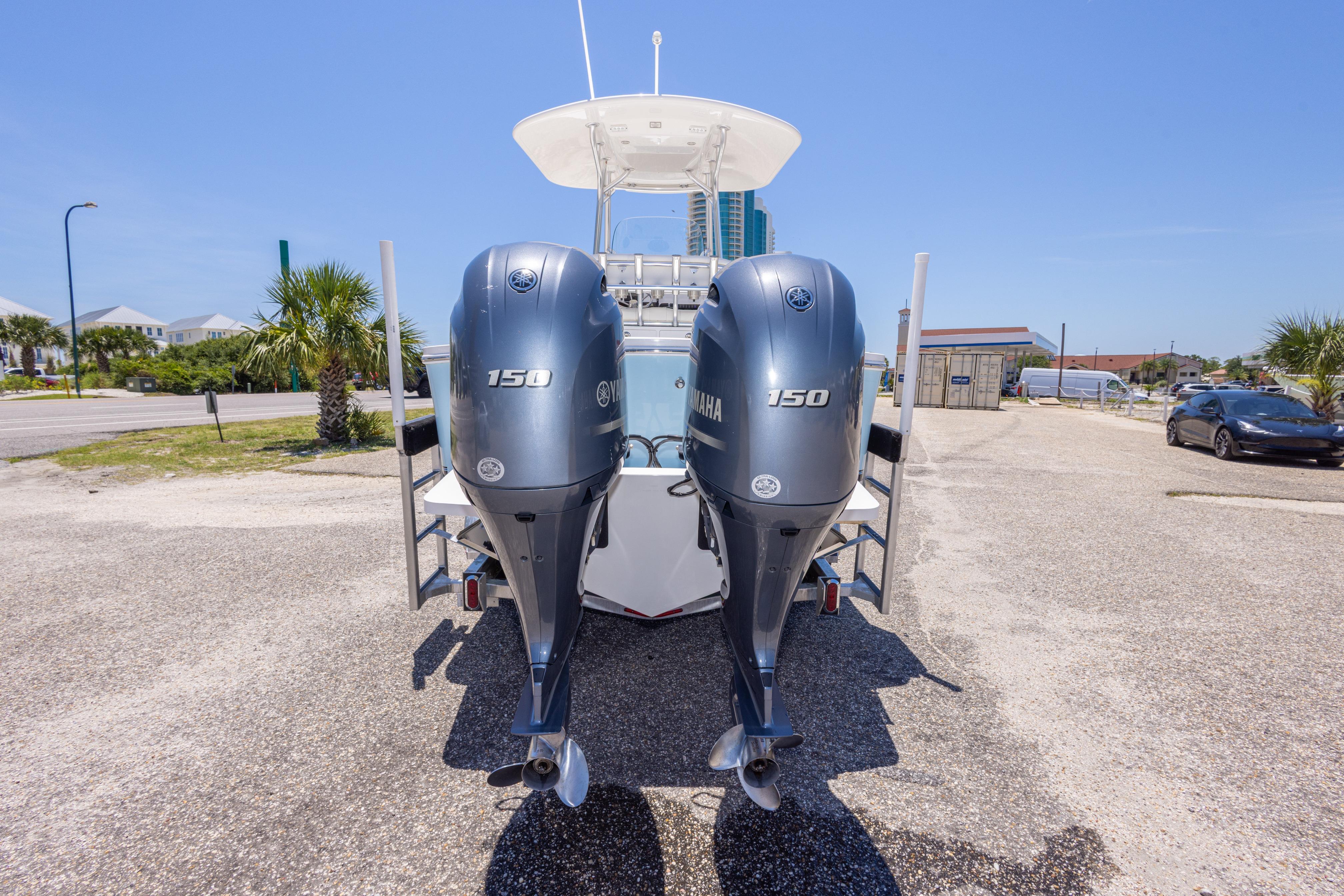 2019 Regulator 23 Center Console boat with dual Yamaha 150 engines, parked outdoors.