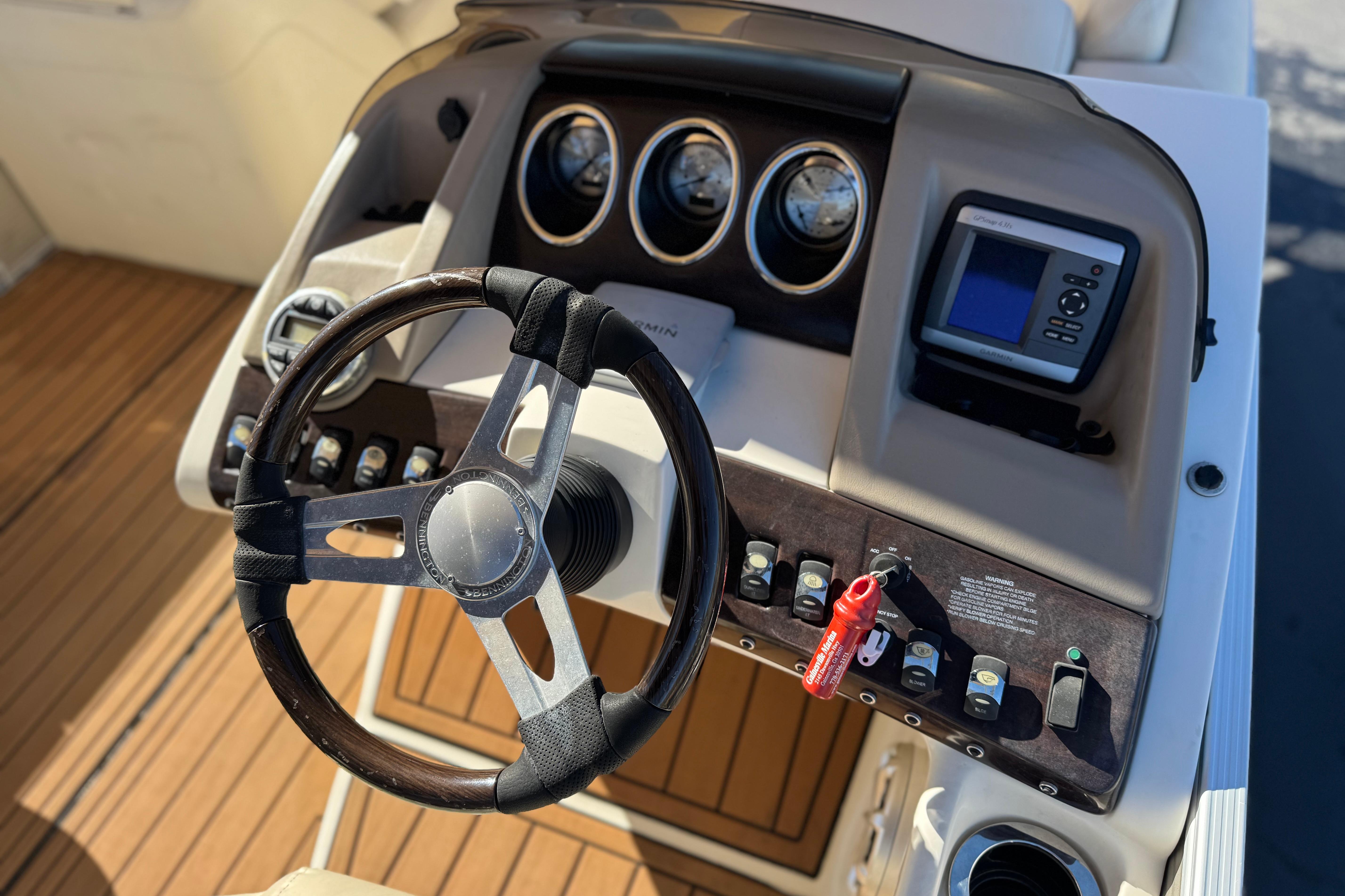2013 Bennington 2575QCW I/O boat dashboard with steering wheel and control panel.