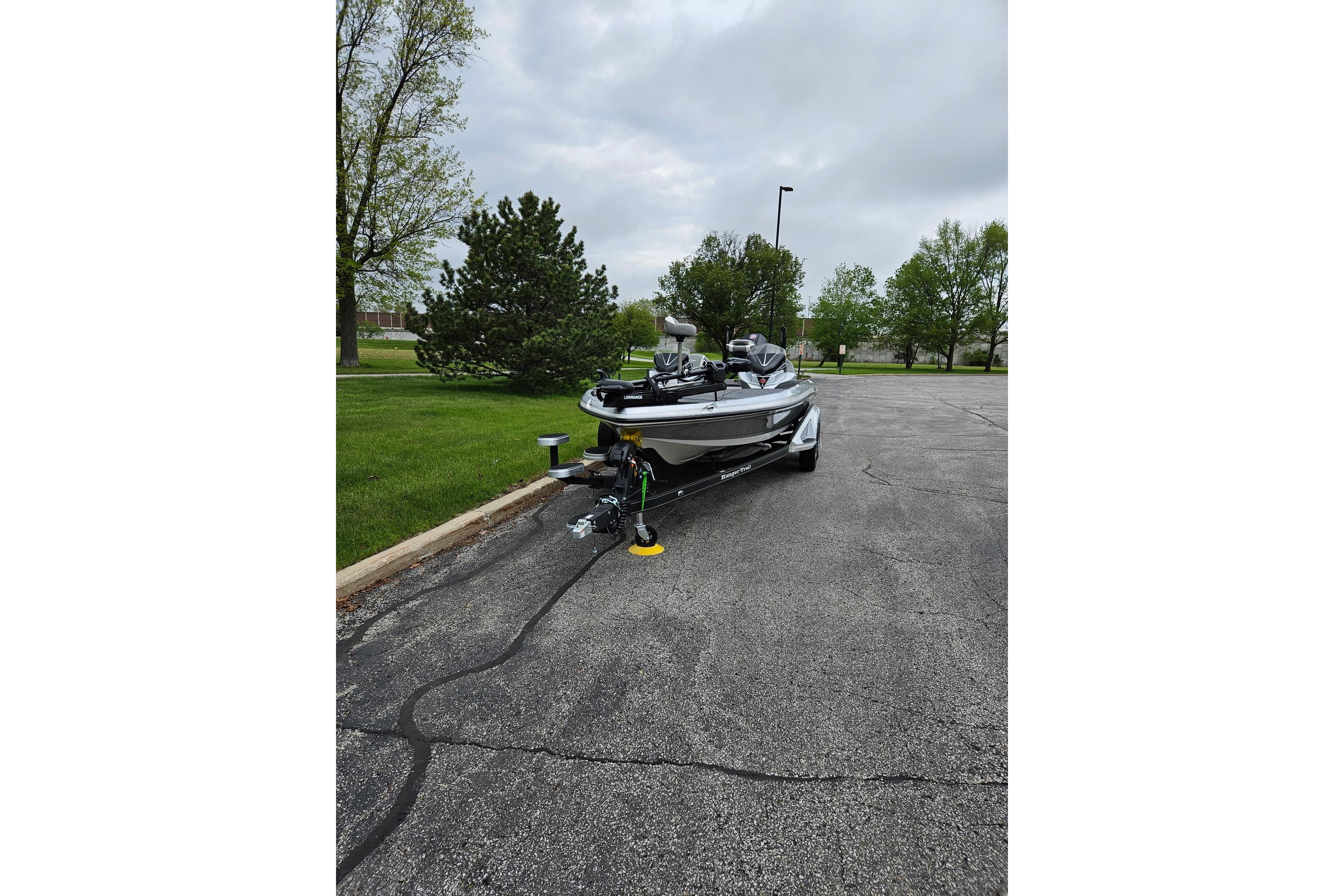 2026 Ranger Z521R Cup-Equipped boat parked on pavement with green trees.