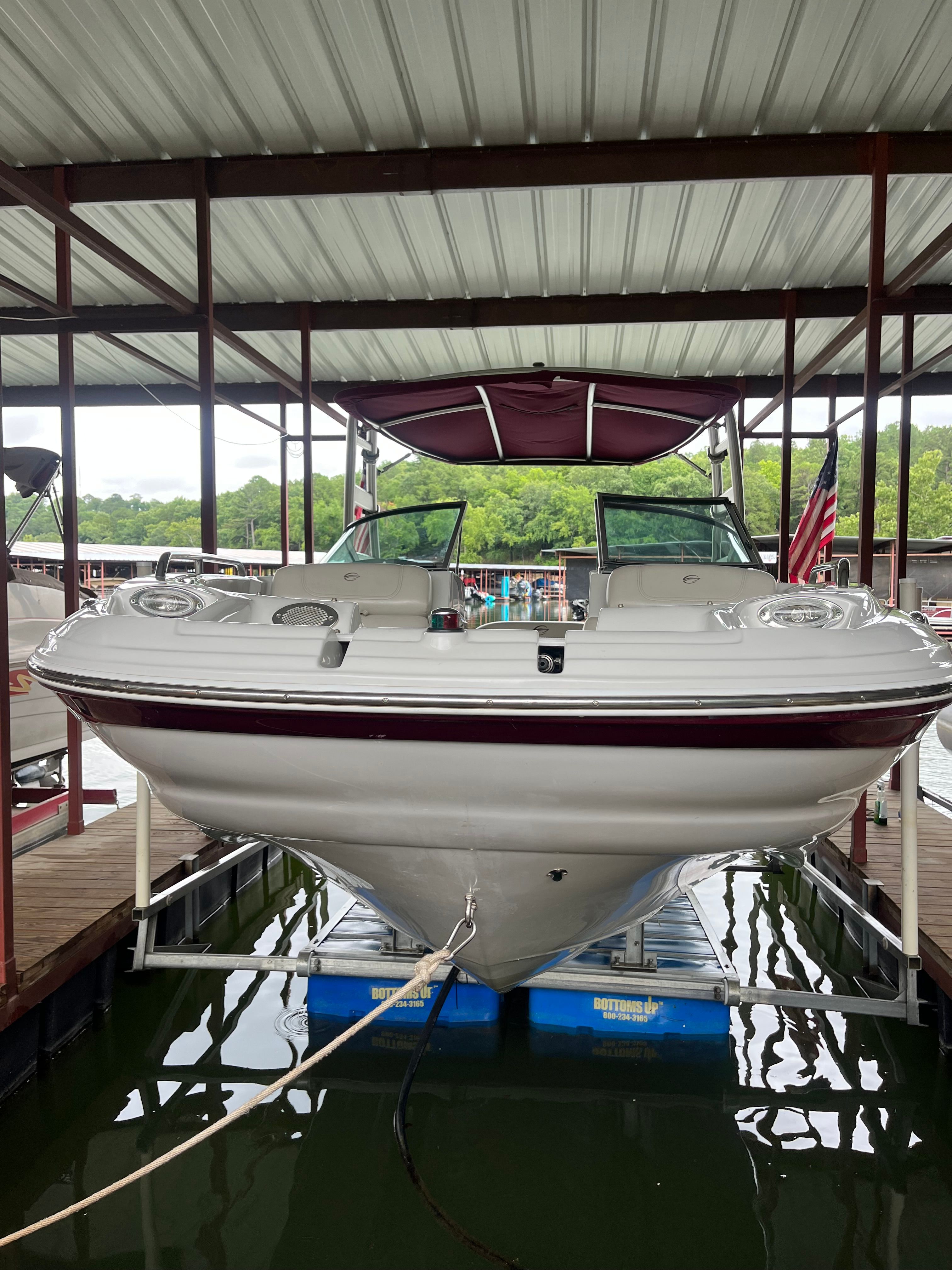 A 2008 Crownline 252EX boat is docked under a covered shelter.
