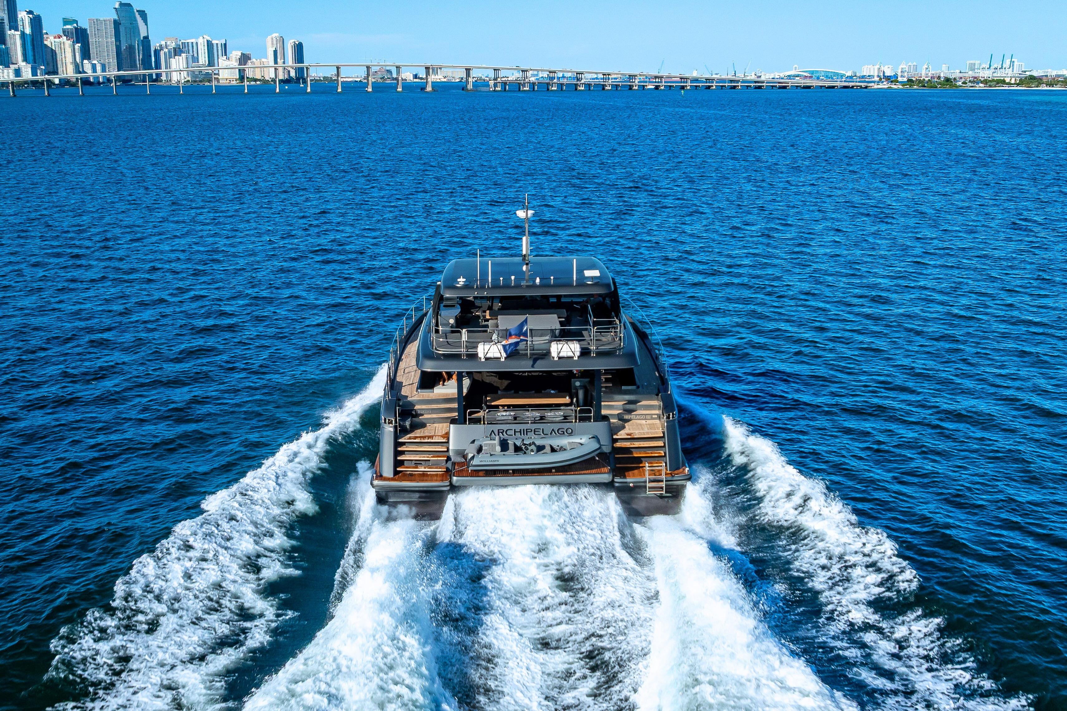Luxury Sunreef 60 Power yacht cruising on blue ocean near city skyline, 2026 model.
