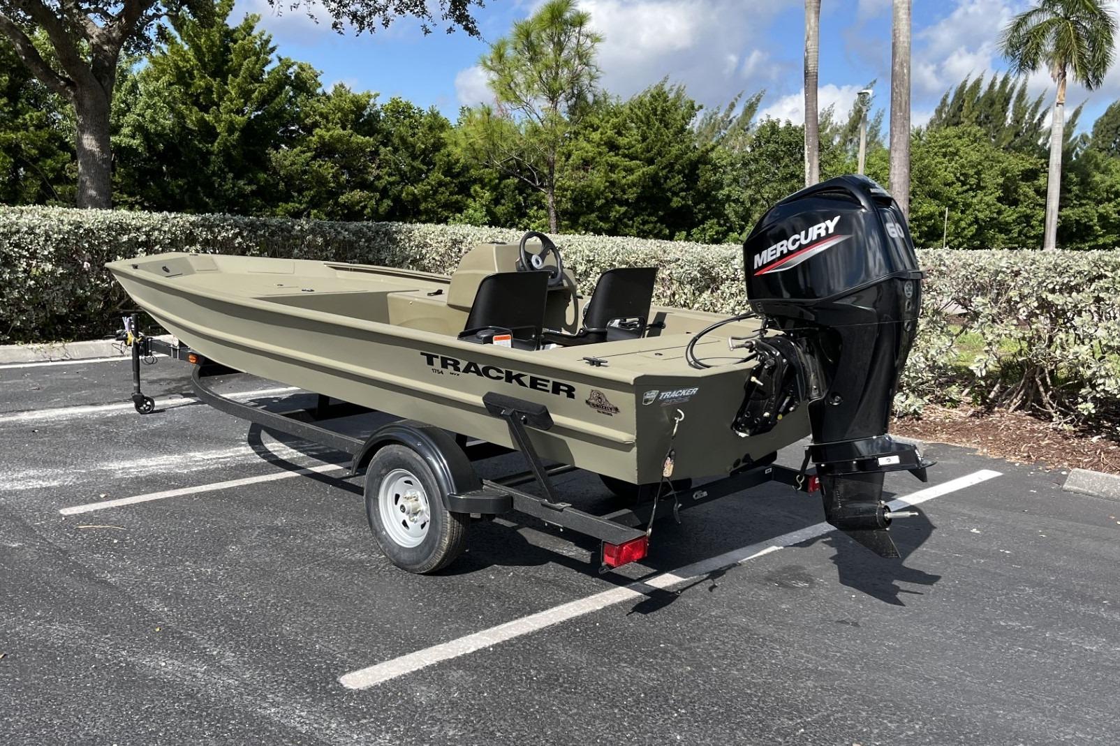 2026 Tracker Grizzly 1754 SC boat with Mercury engine on trailer in parking lot.