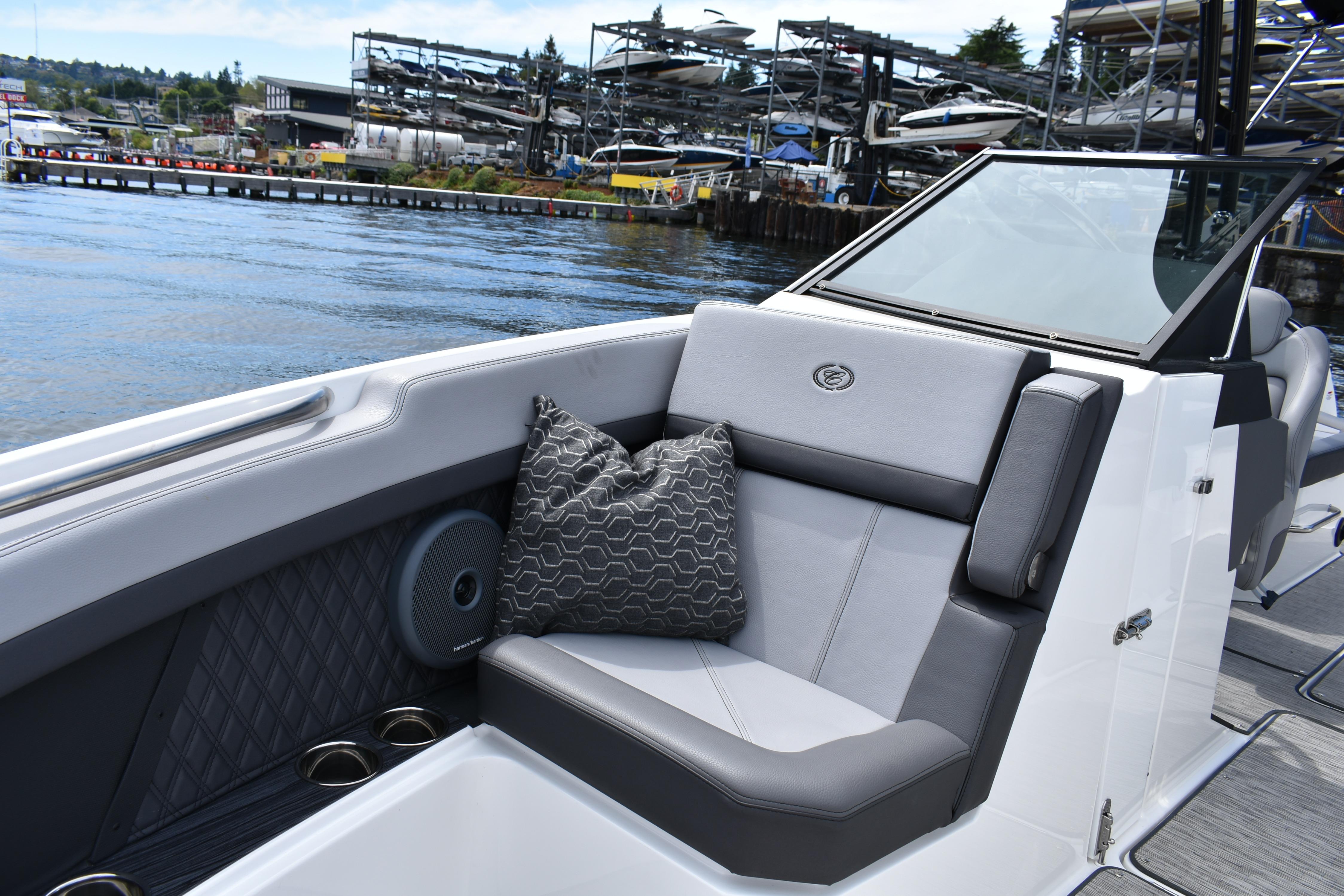 2023 Cobalt R8 boat interior with gray seating, patterned pillow, and waterfront view.