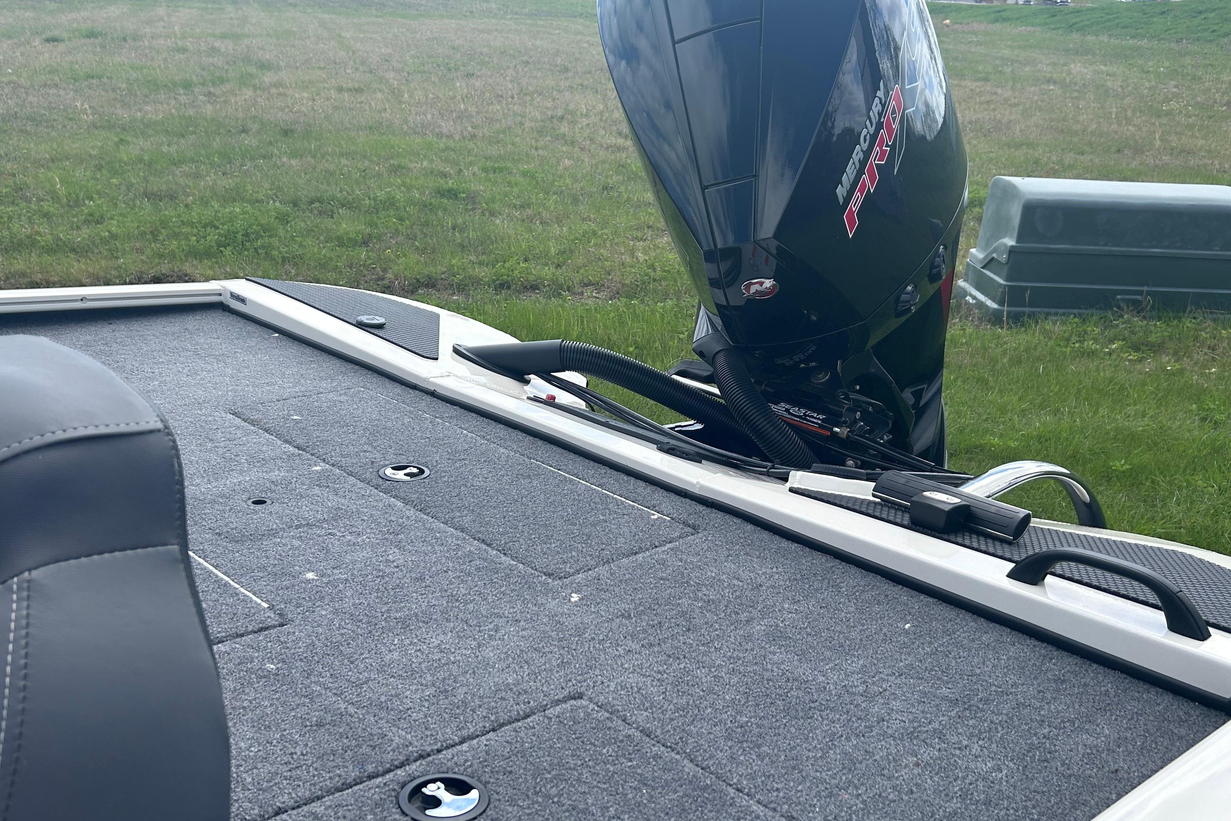 2025 Tracker Savage 215 boat deck with Mercury Pro motor in grassy area.