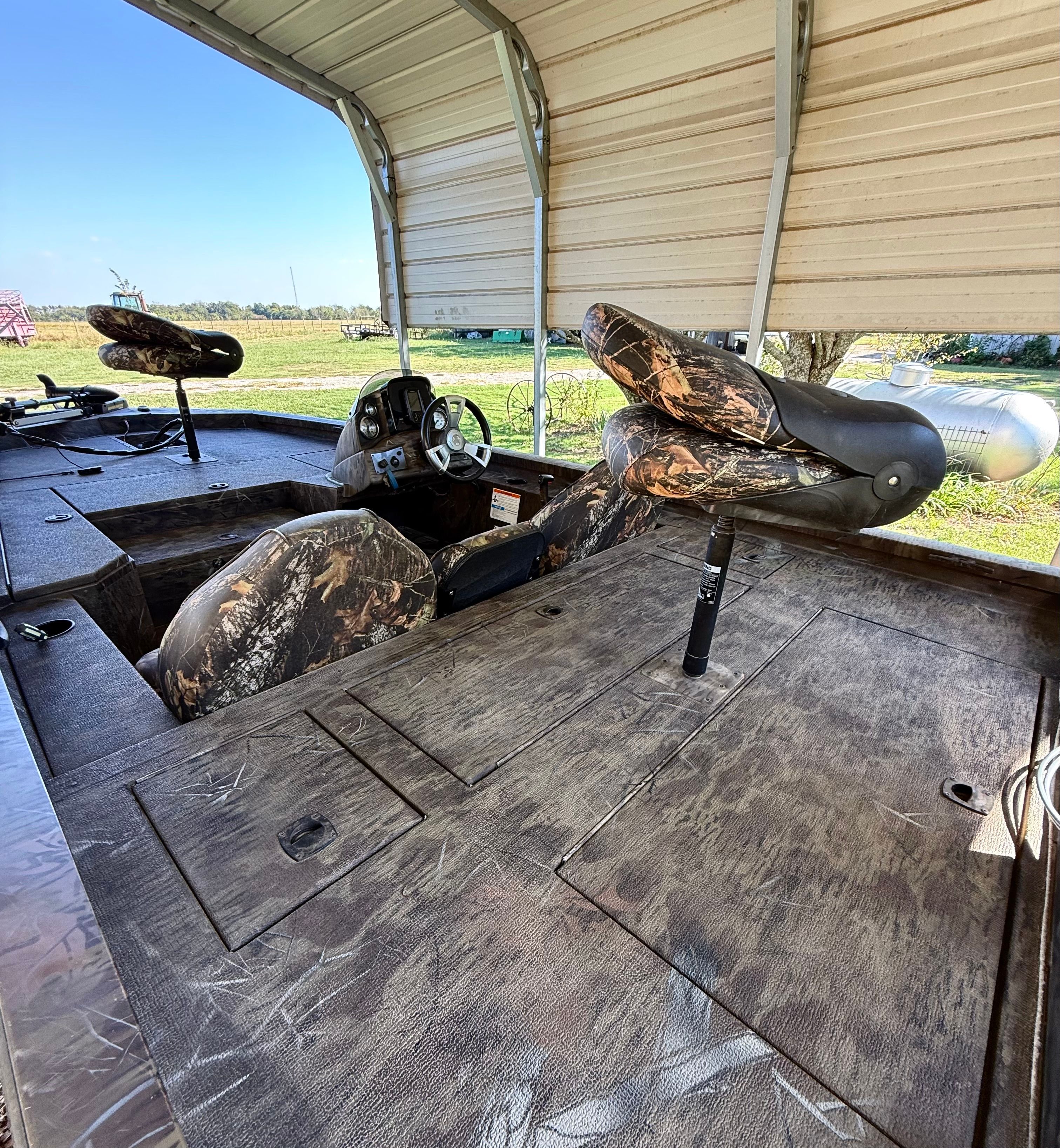 A 2017 G3 Sportsman 17 Camo boat with camouflage pattern, featuring seats and a steering console.