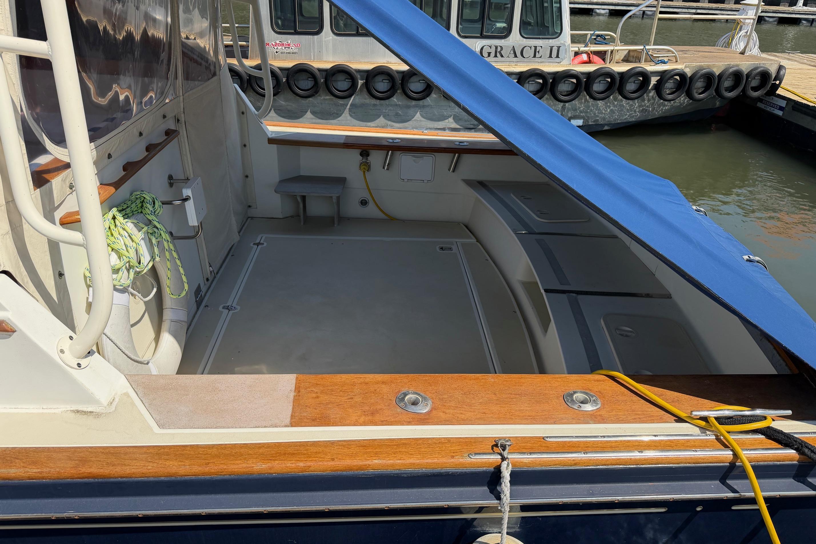 2003 Little Harbor WhisperJet 36 boat with open deck and blue canopy at dock.