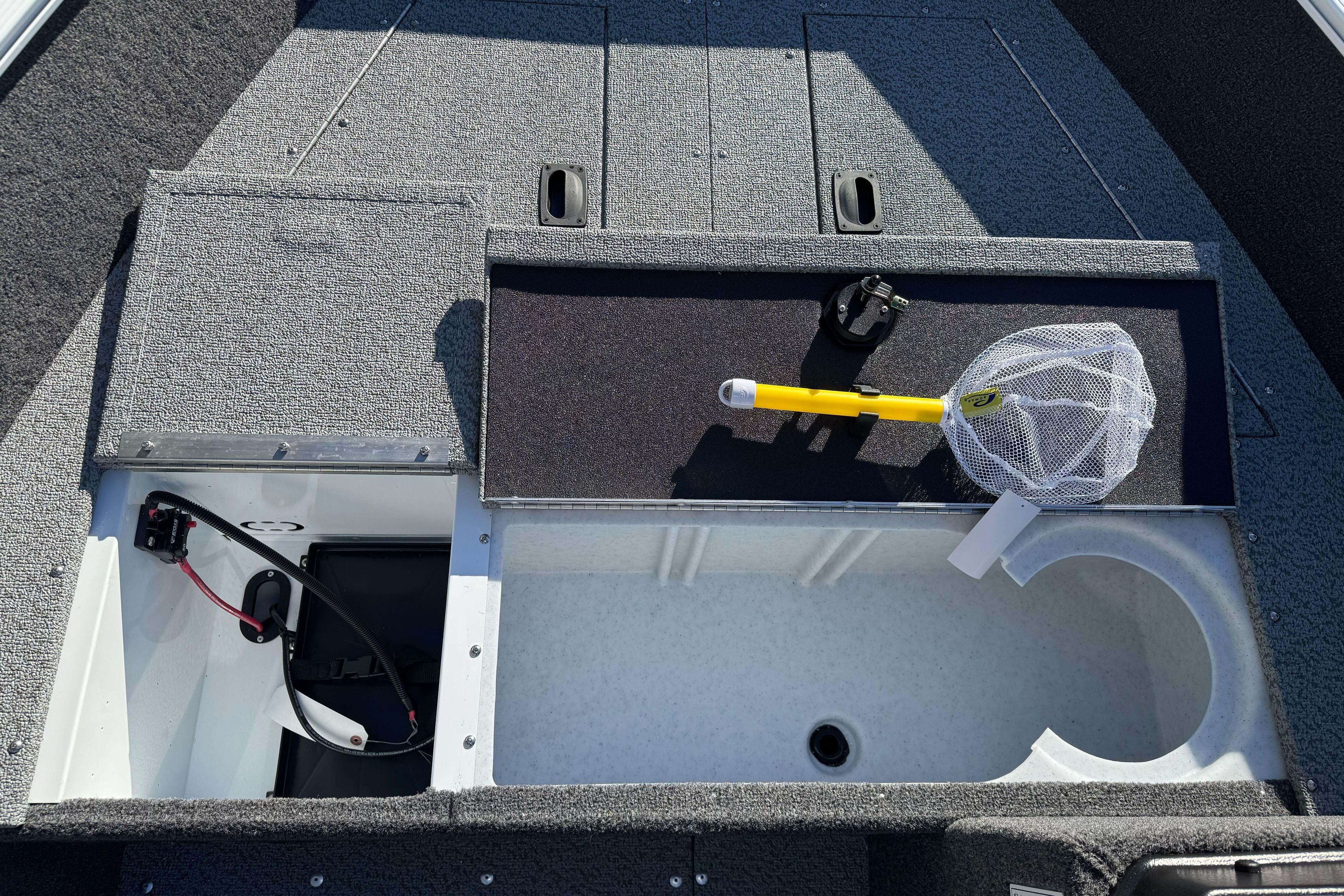 2026 Lund 1650 Angler SS boat interior with storage compartments and fishing gear.