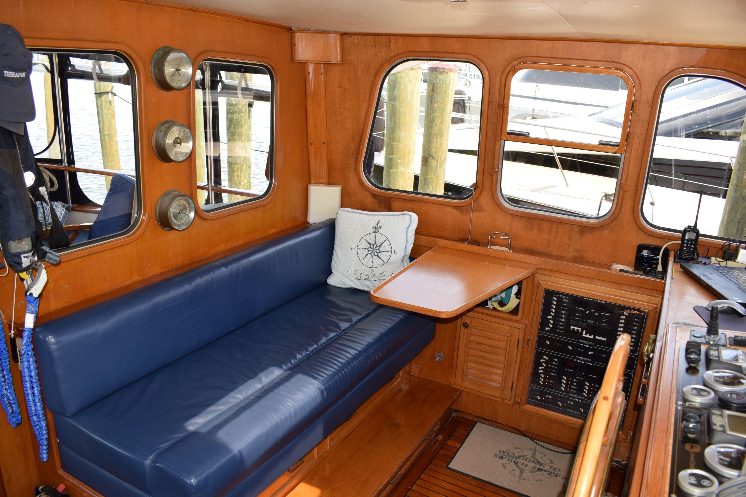 Interior of 1980 Cheoy Lee 52 Motorsailer with blue seating and wooden accents.