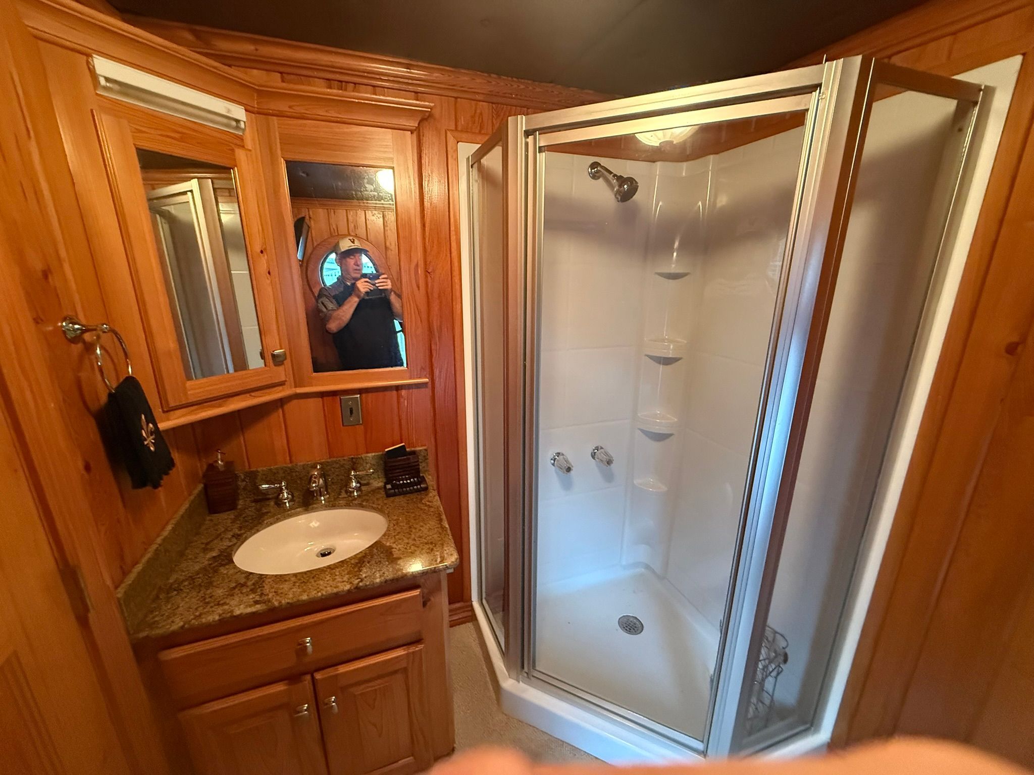 Wood-paneled bathroom with a shower and sink.