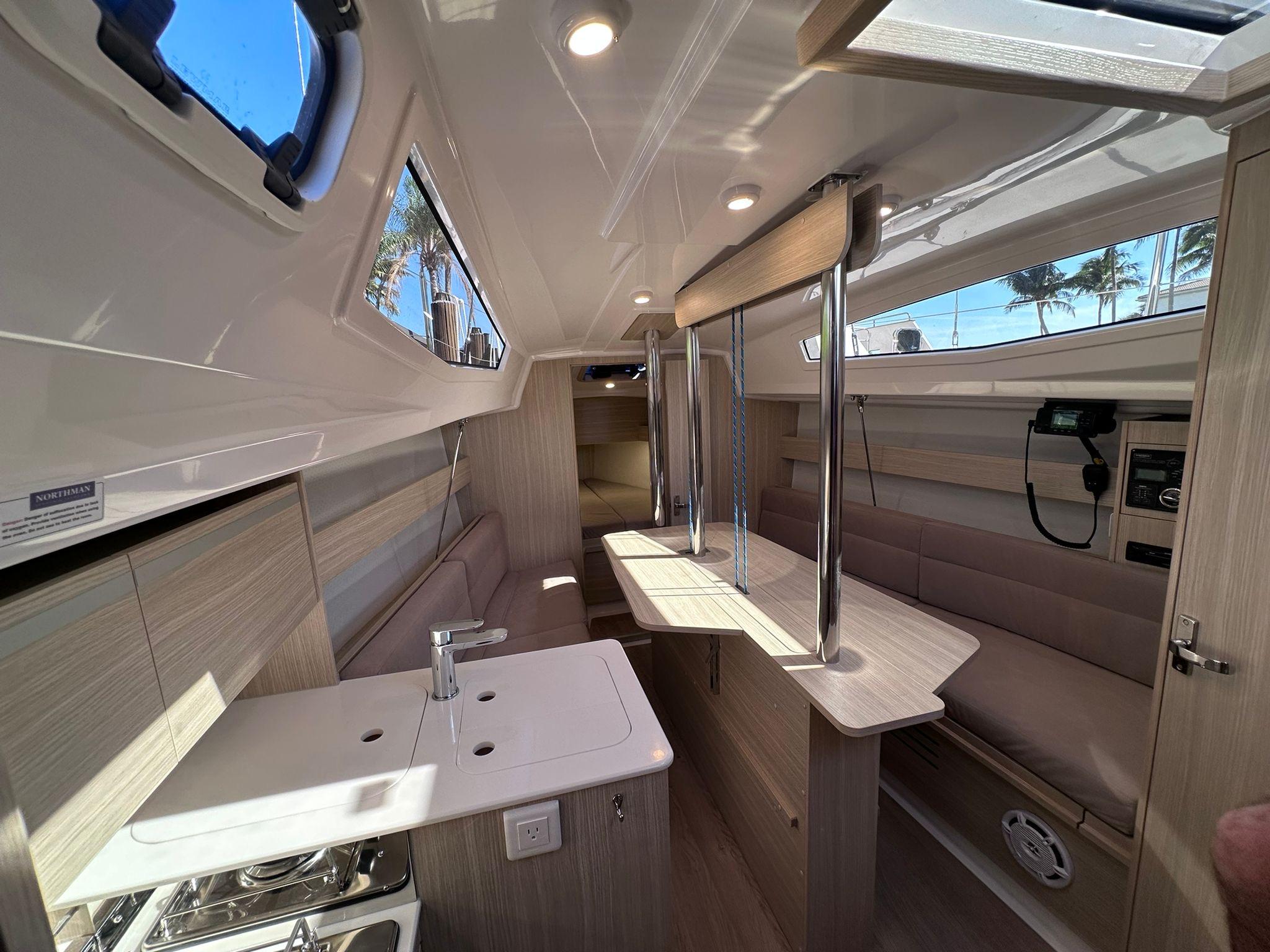 Interior of 2025 Maxus 26 yacht, featuring modern design, compact kitchen, and seating area.