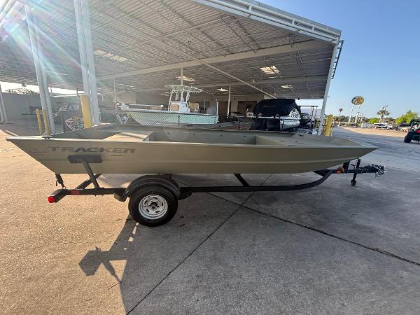 2025 Tracker GRIZZLY 1860 Utility boat on trailer in a covered storage area.