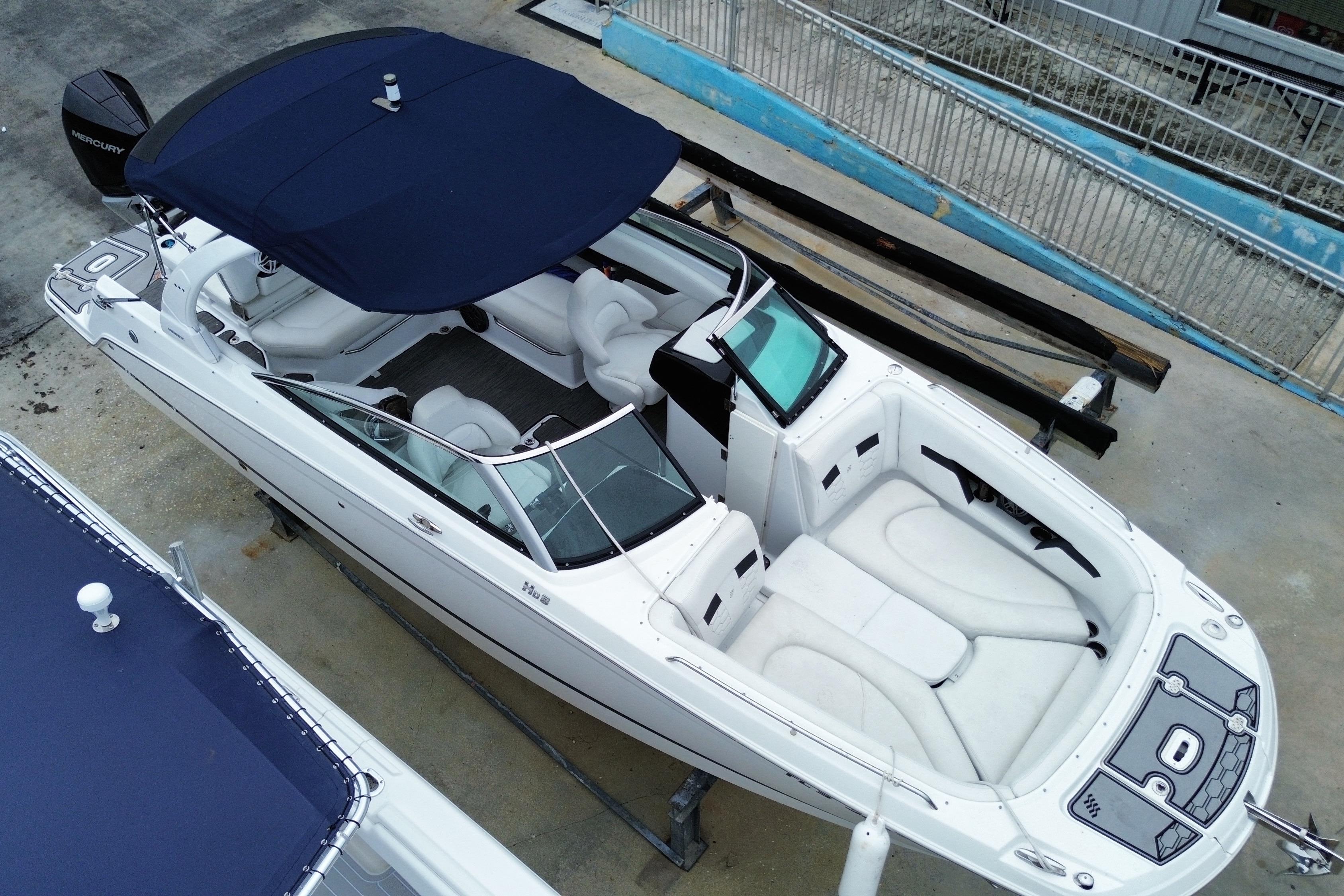 2022 Four Winns HD8 OB boat with blue canopy, docked on concrete surface.