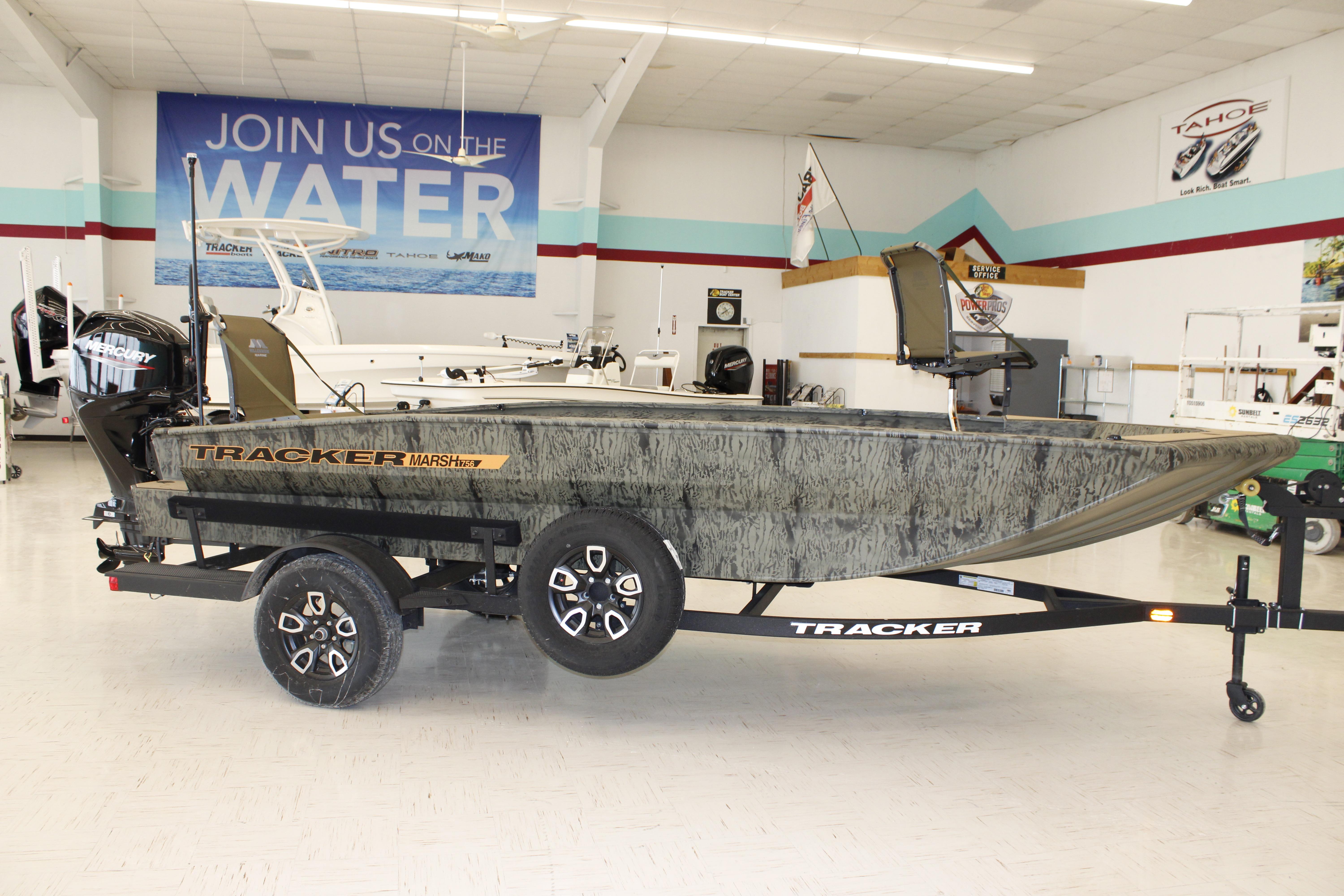2026 Tracker Grizzly 1756 T Marsh boat displayed in showroom with trailer.