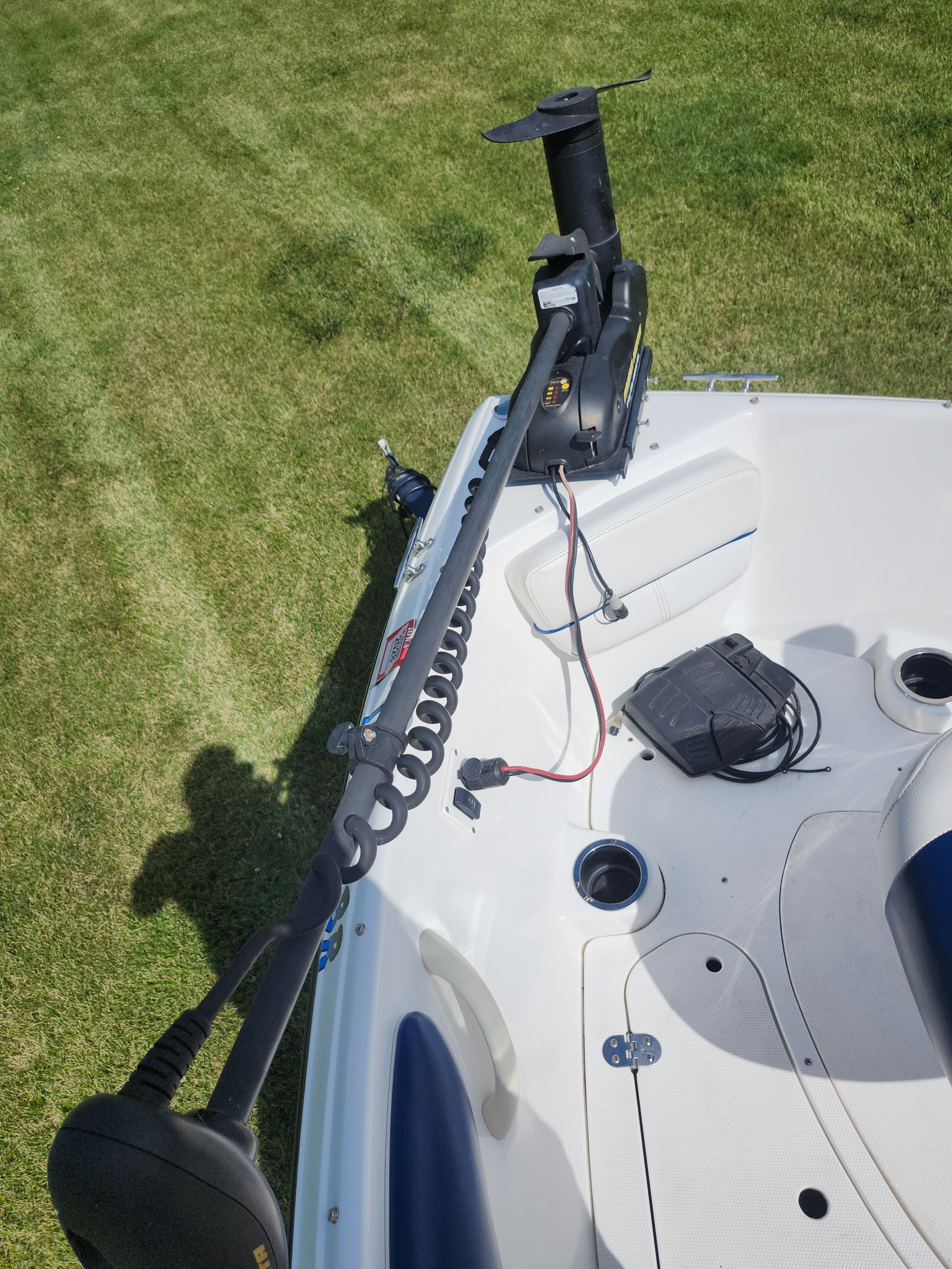 A 2013 Rinker 186 Captiva fish/ski boat on grass, featuring a trolling motor.