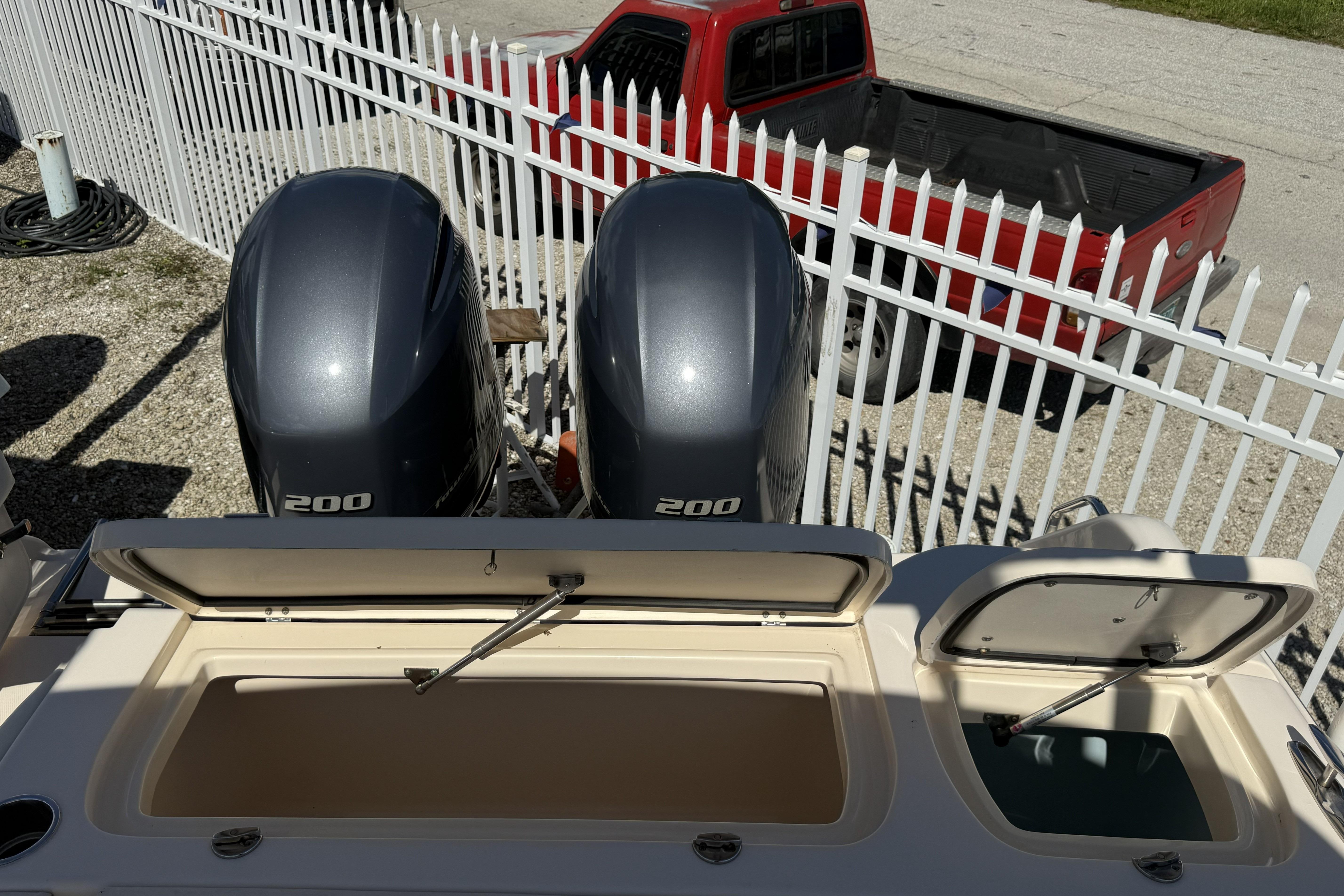 2014 Grady-White Freedom 275 boat with dual 200 horsepower engines, parked near a red truck.