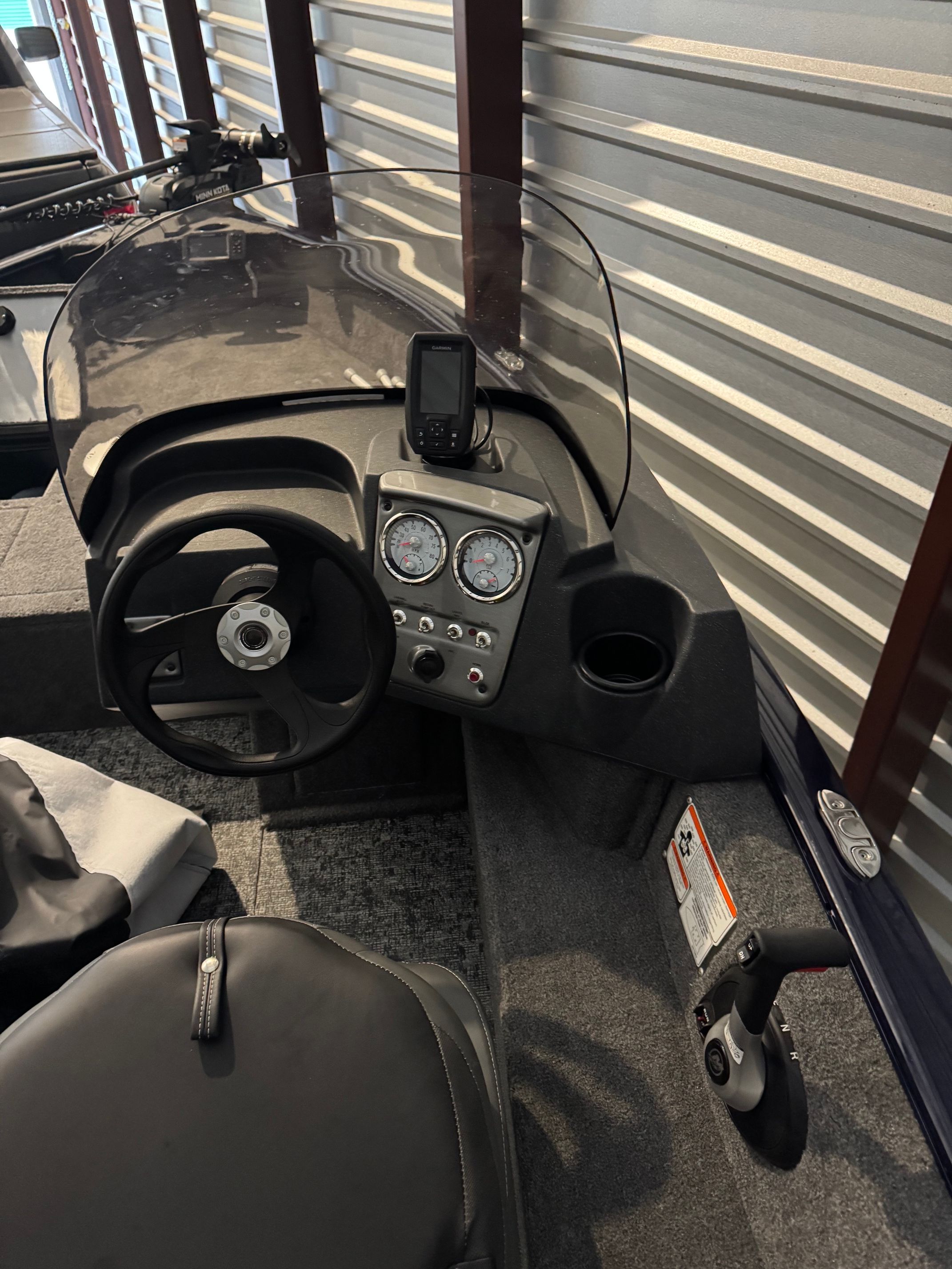 The image shows the cockpit of a Tracker Pro Guide V-16 SC with steering wheel, gauges, and a screen.