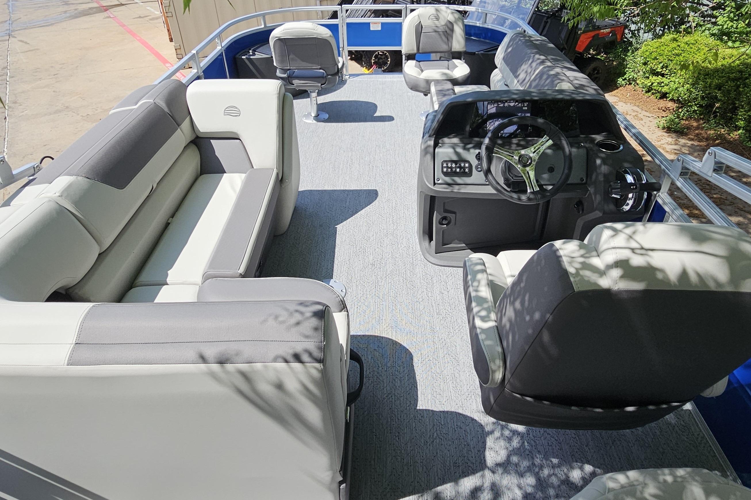 2026 Sun Tracker Fishin' Barge 20 DLX interior with seating and steering console.