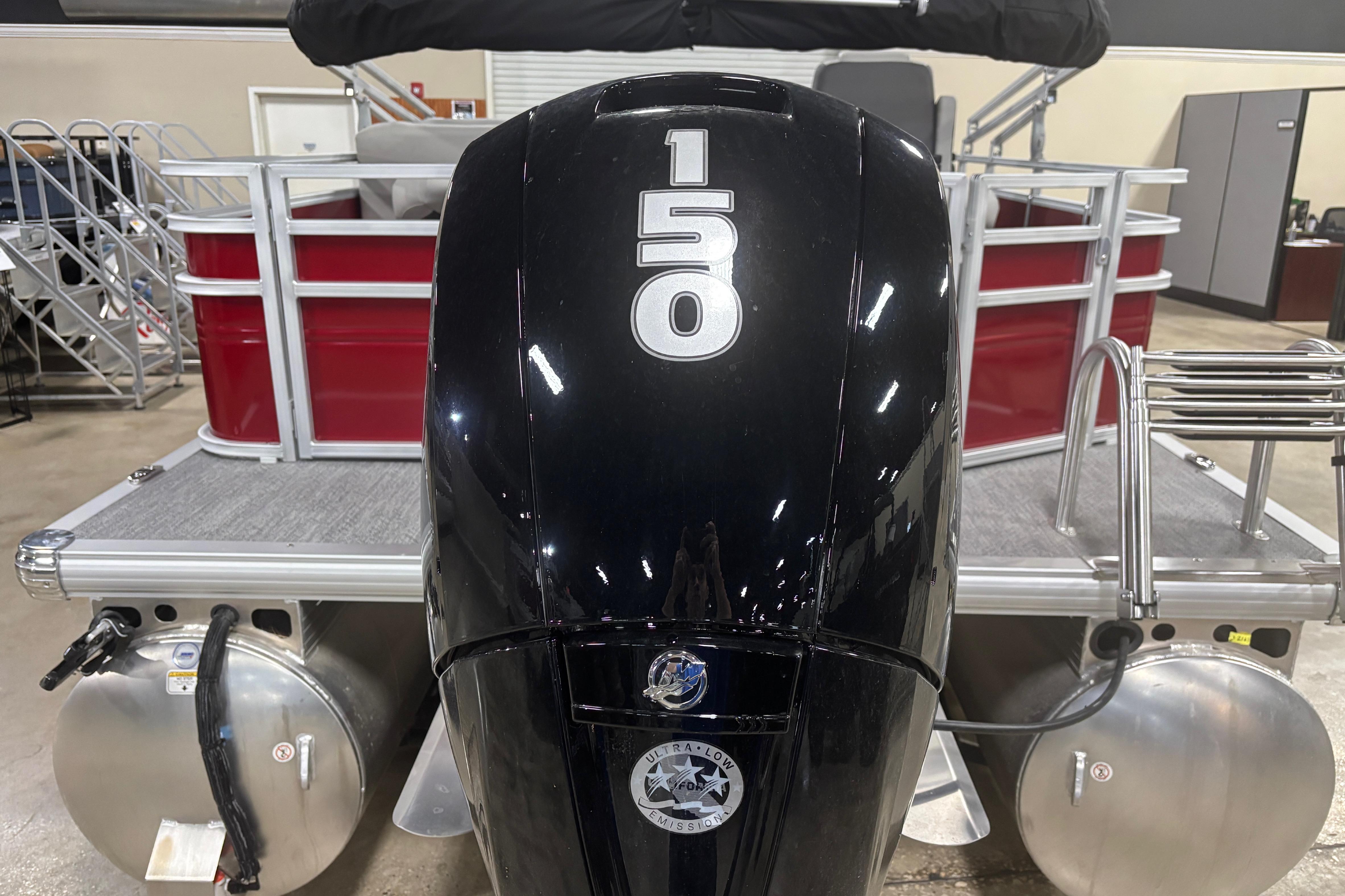 2026 Sun Tracker Fishin' Barge 22 DLX with powerful 150 HP outboard motor.