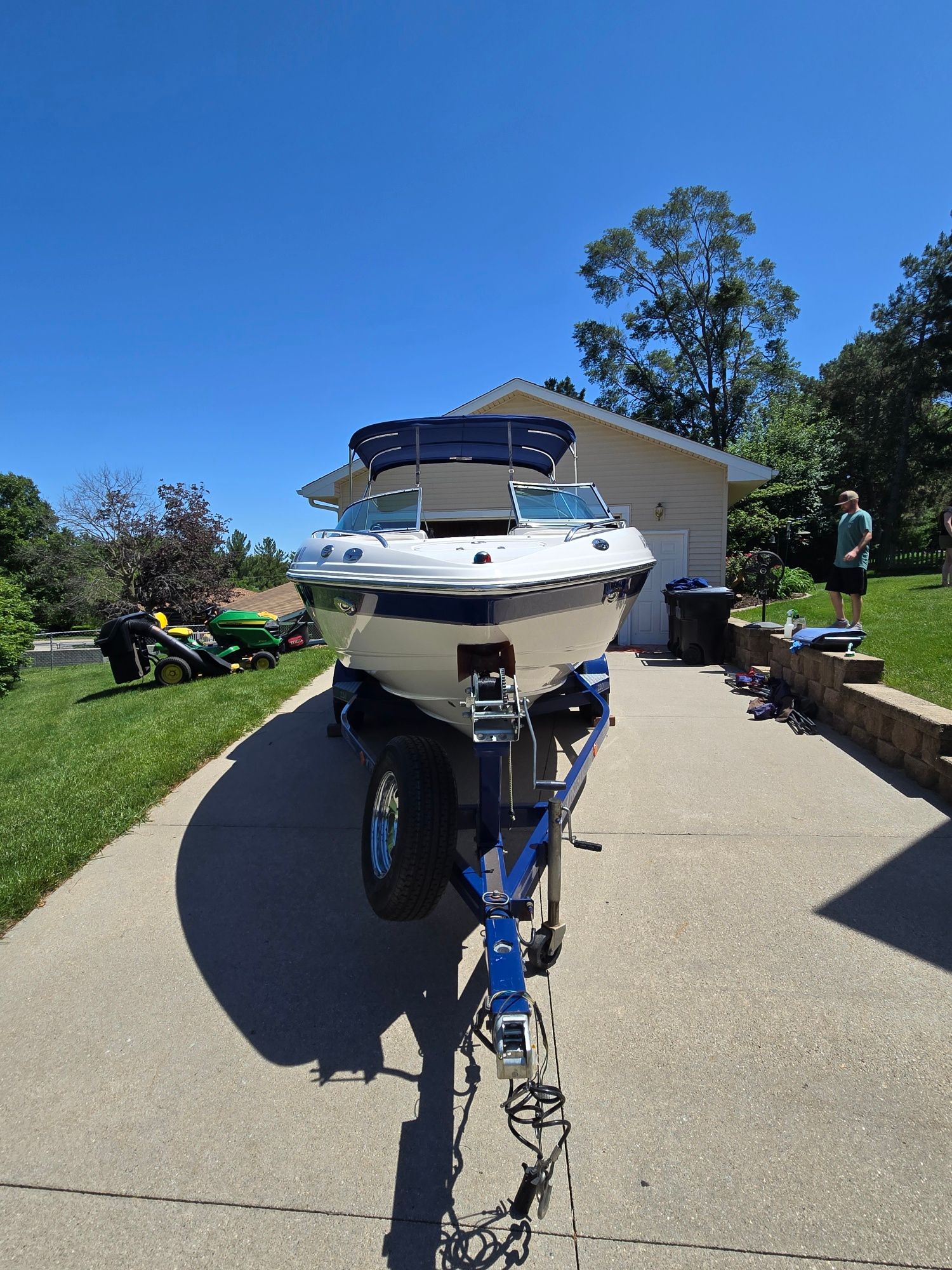 A 2005 Chaparral 220 SSi boat on a trailer in a driveway.