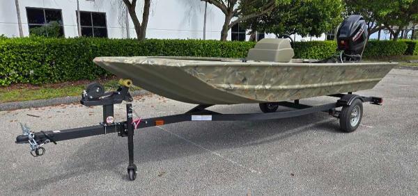 2025 Tracker Grizzly 1648 SC boat on trailer, parked outdoors.