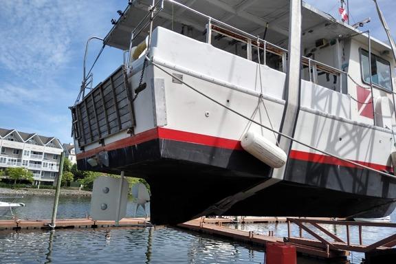 1980 Thompson Passenger and Dive Trawler lifted at dockside, with waterfront buildings in background.