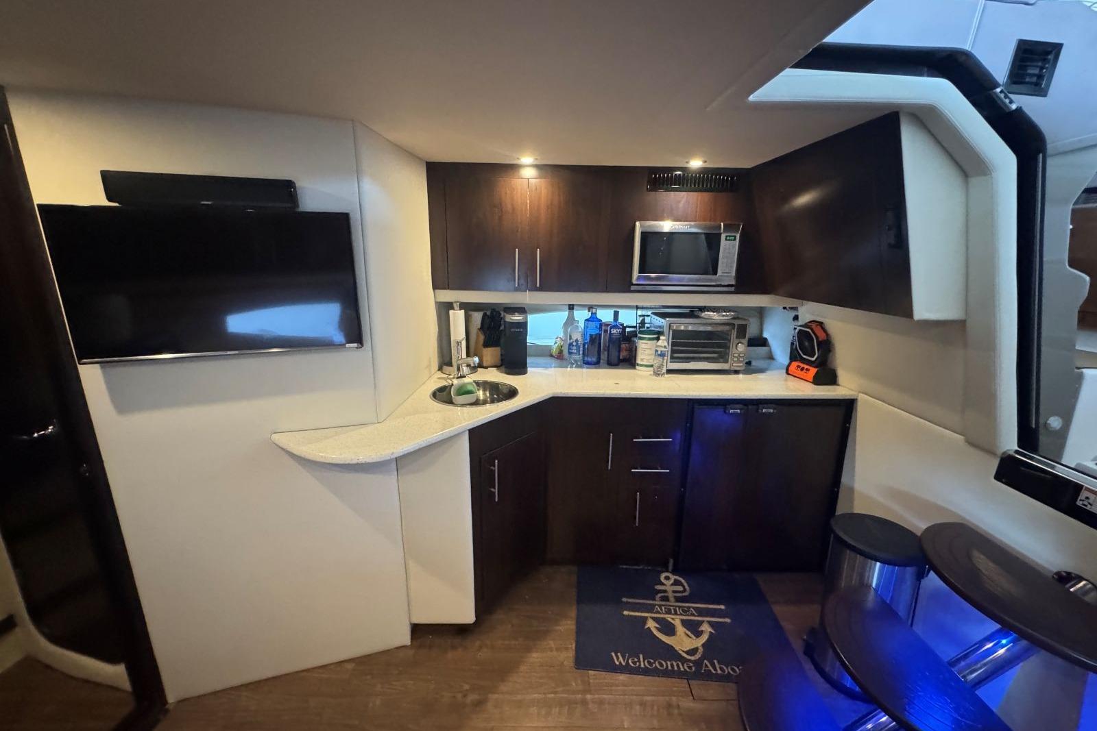 Interior of 2016 Regal 46 Sport Coupe yacht with kitchenette and modern amenities.