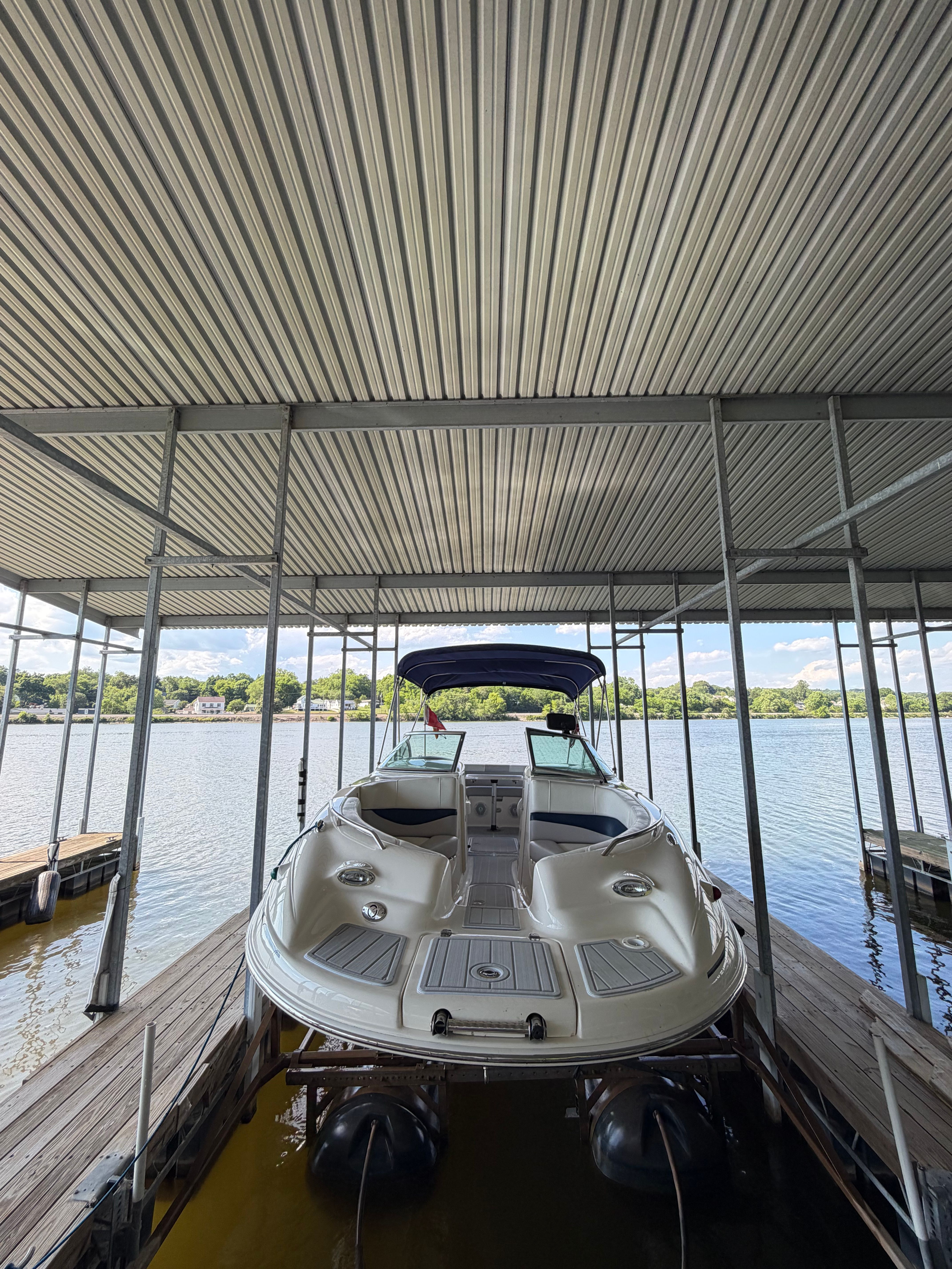 2010 Bryant 255 boat in covered dock on lake.