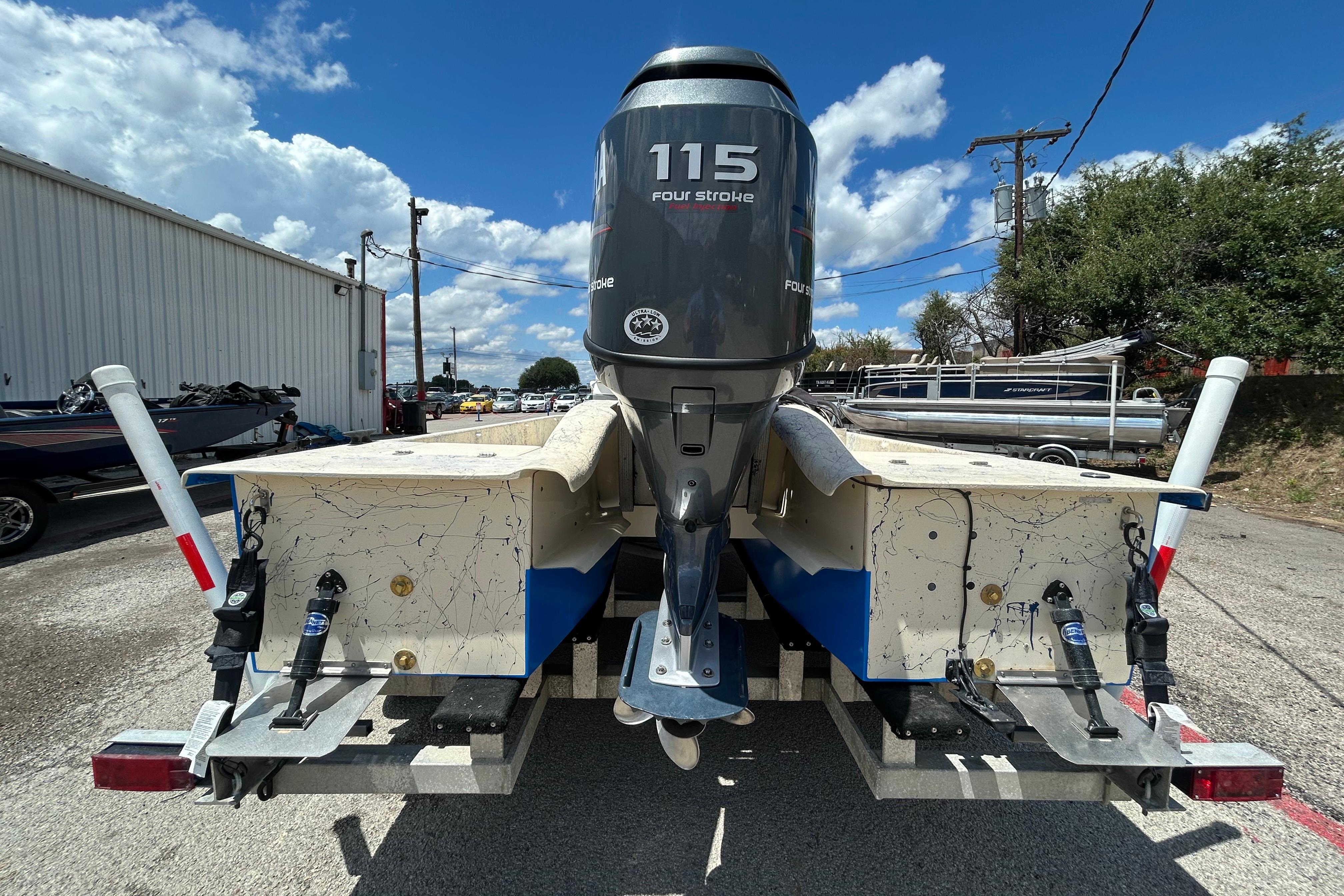 2007 Flats Cat 19 boat with 115 horsepower engine on trailer, outdoor setting.