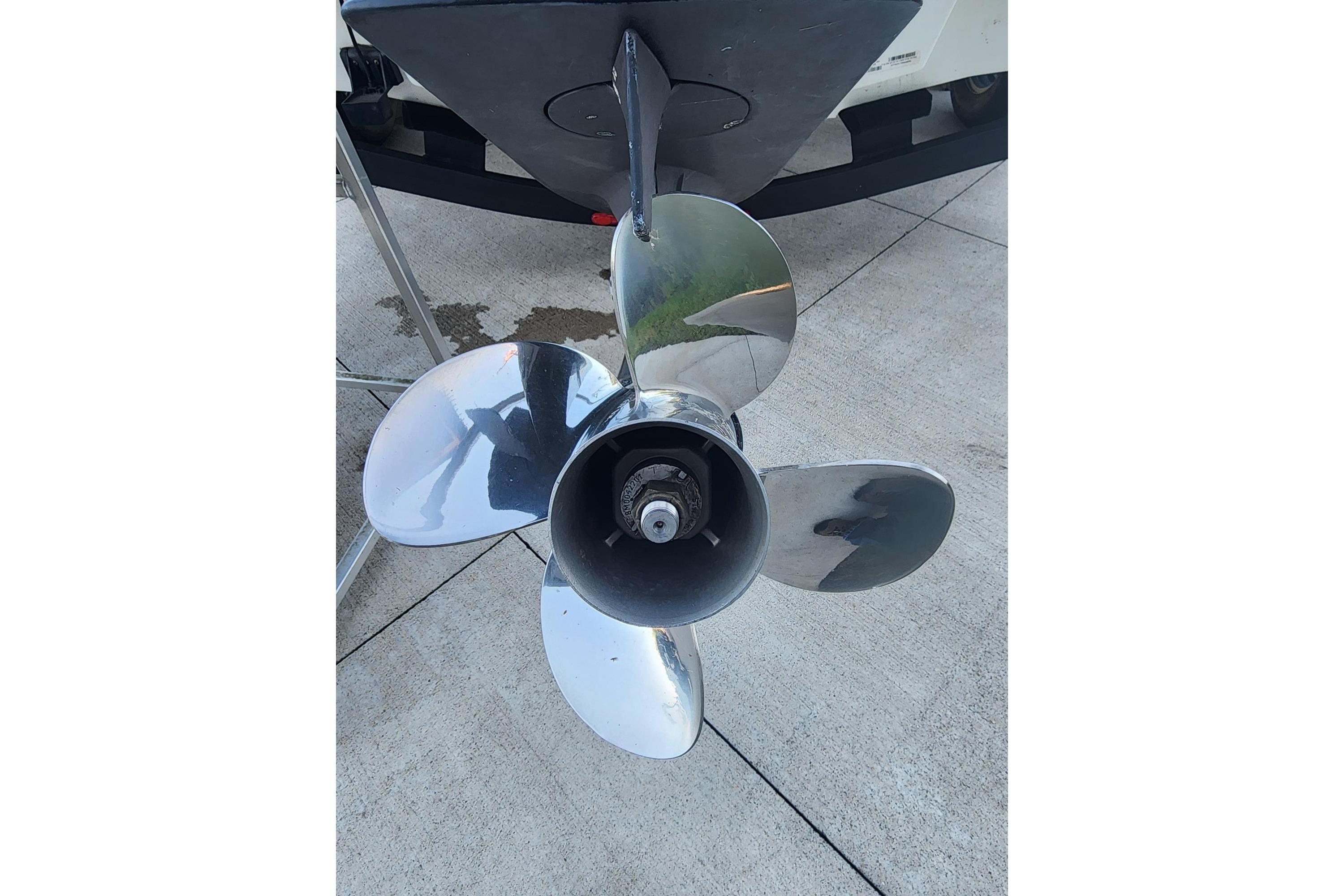 2023 Tahoe T18 boat propeller on concrete surface, showcasing shiny metal blades.