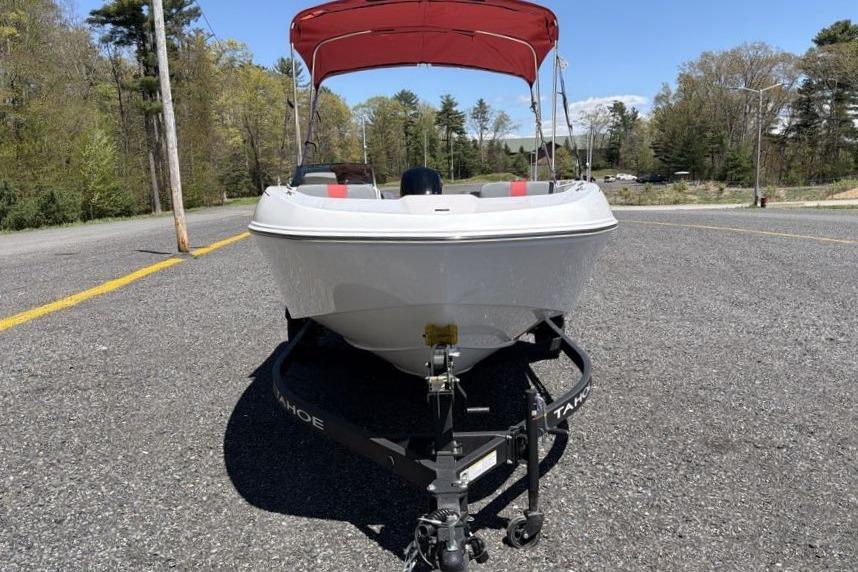 2026 Tahoe T18 boat with red canopy on trailer, parked on asphalt road.