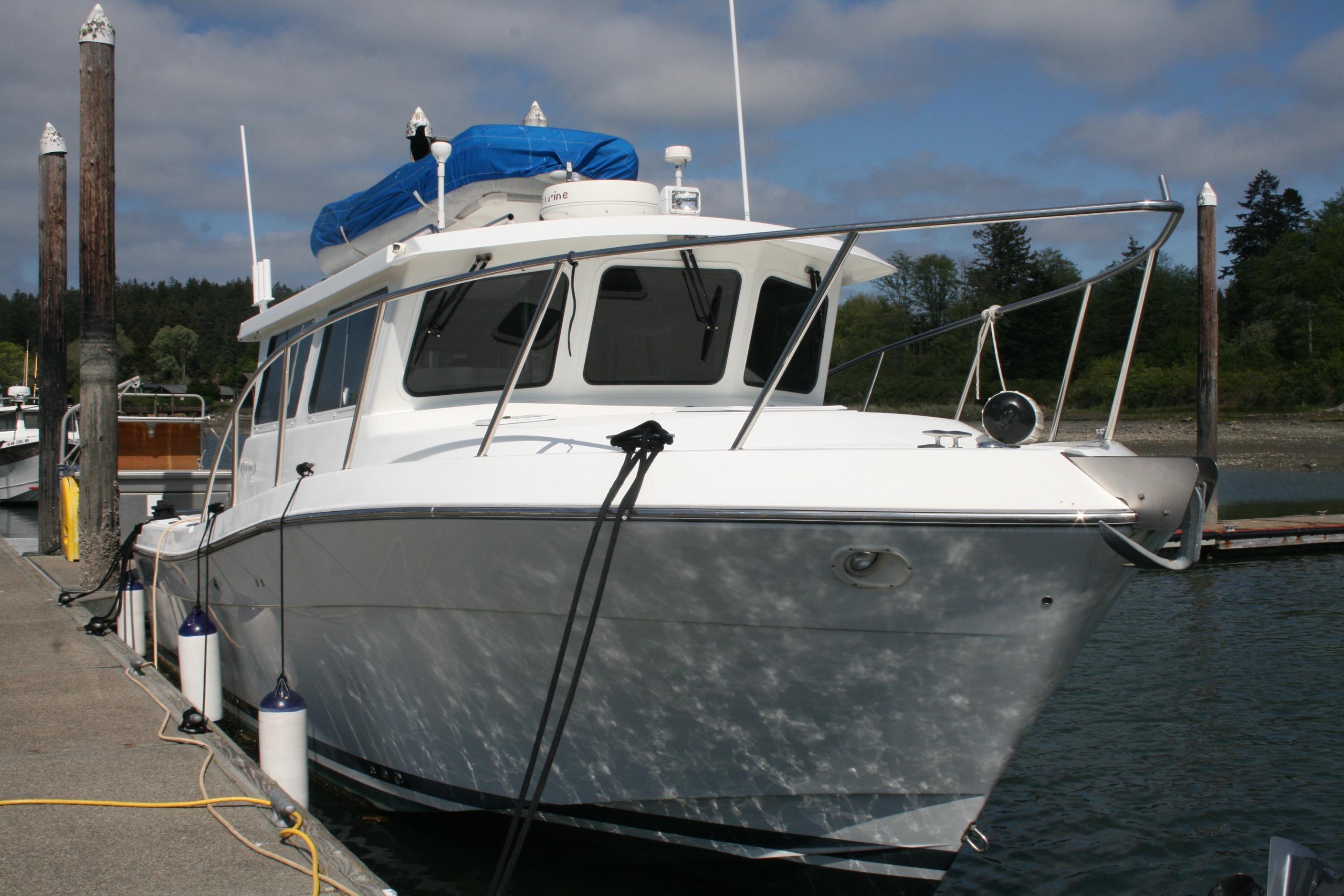 2005 Ocean Sport 30' boat docked at marina under cloudy sky.