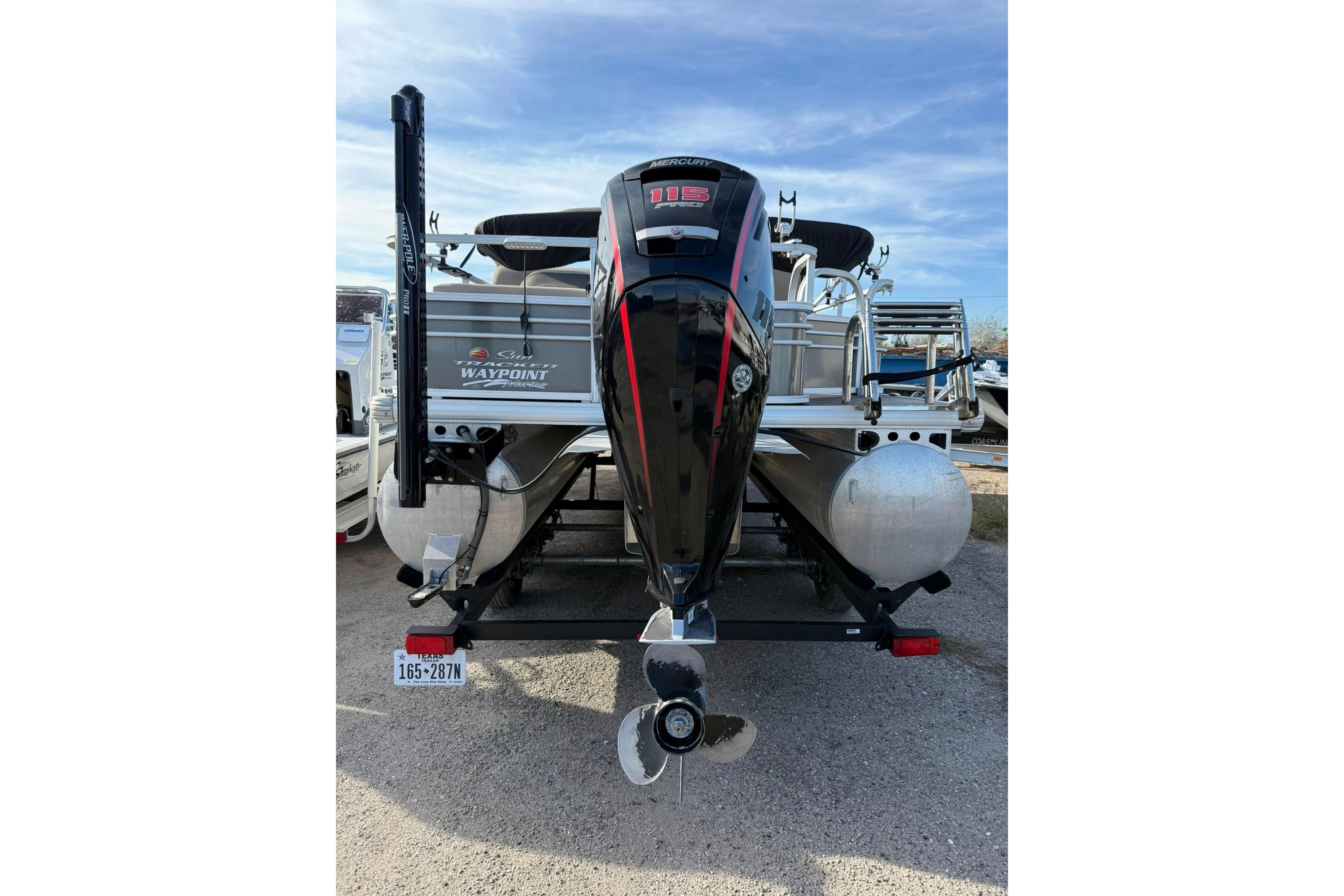 2023 Sun Tracker Fishin' Barge 22 DLX pontoon boat with powerful outboard motor.