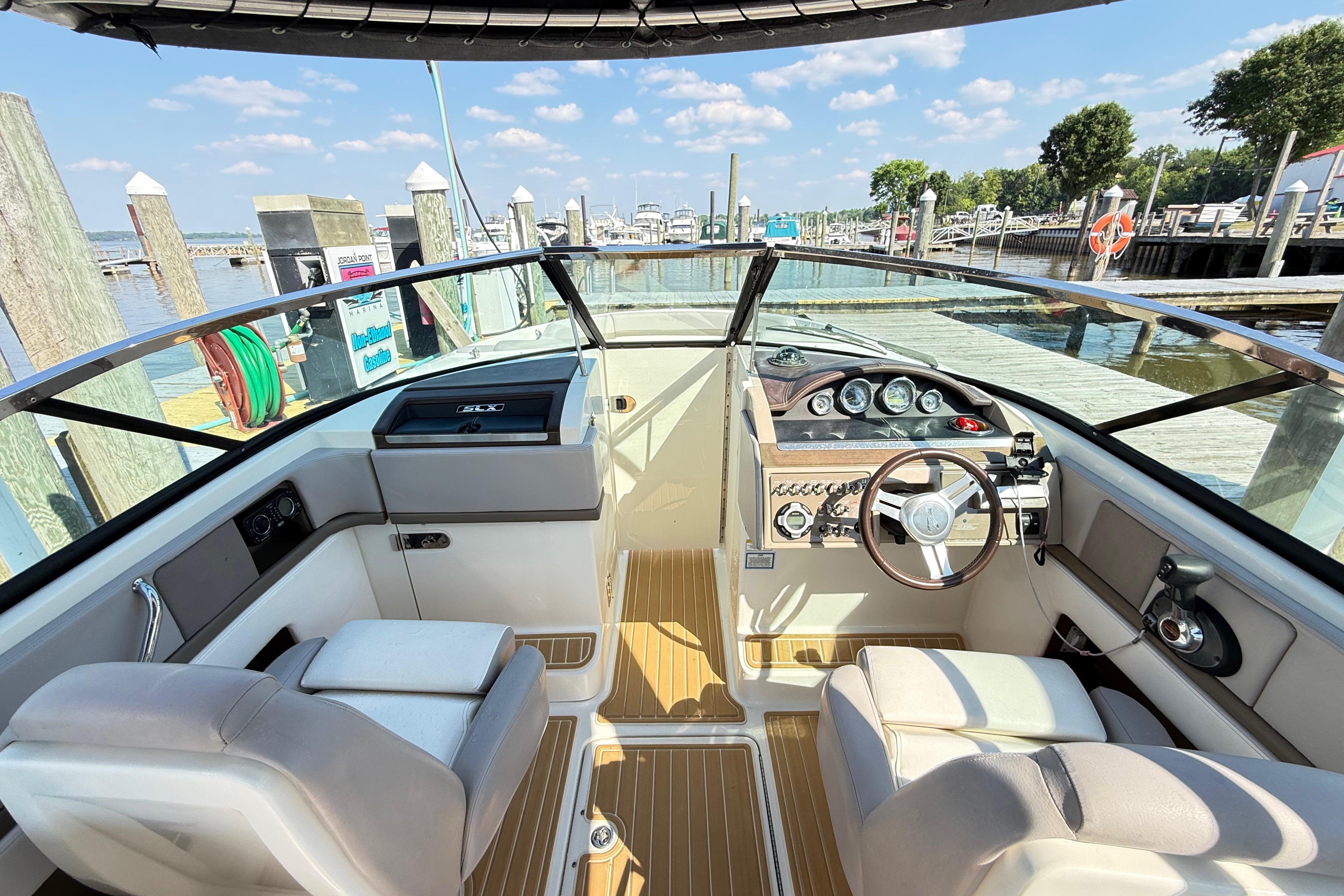 Interior view of 2011 Sea Ray 270 SLX boat at dock, featuring helm and seating.