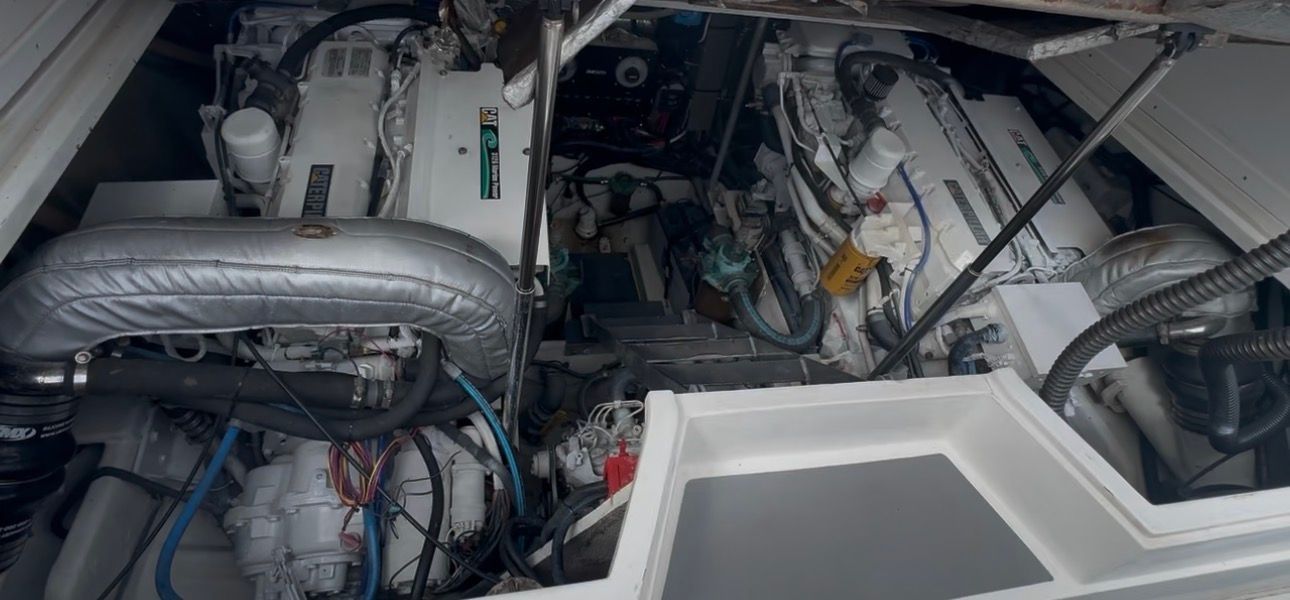 Engine compartment of a 2001 Blackfin Combi with two large engines and various cables.
