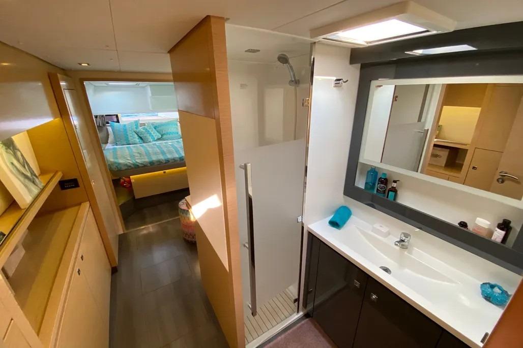 Luxurious interior of 2015 Fountaine Pajot SABA 50 yacht with modern bathroom and cozy bedroom.