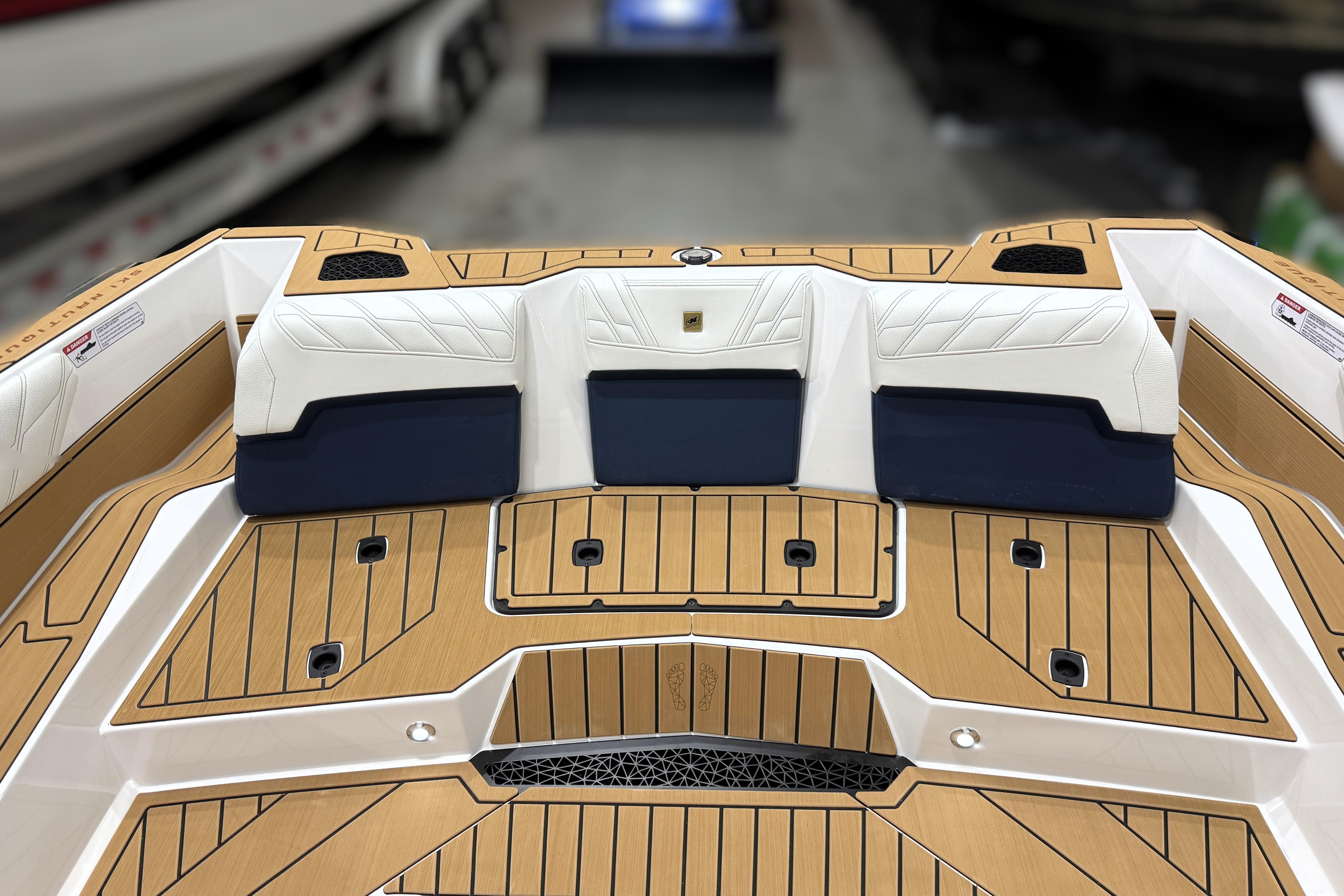2026 Nautique Ski Nautique boat interior with teak flooring and cushioned seating.