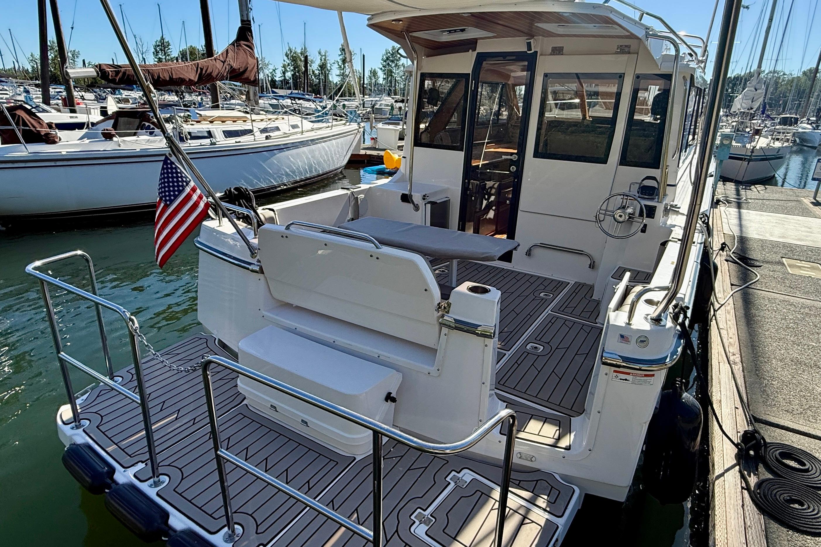 2023 Cutwater C-30 Sedan docked, featuring spacious deck and American flag.