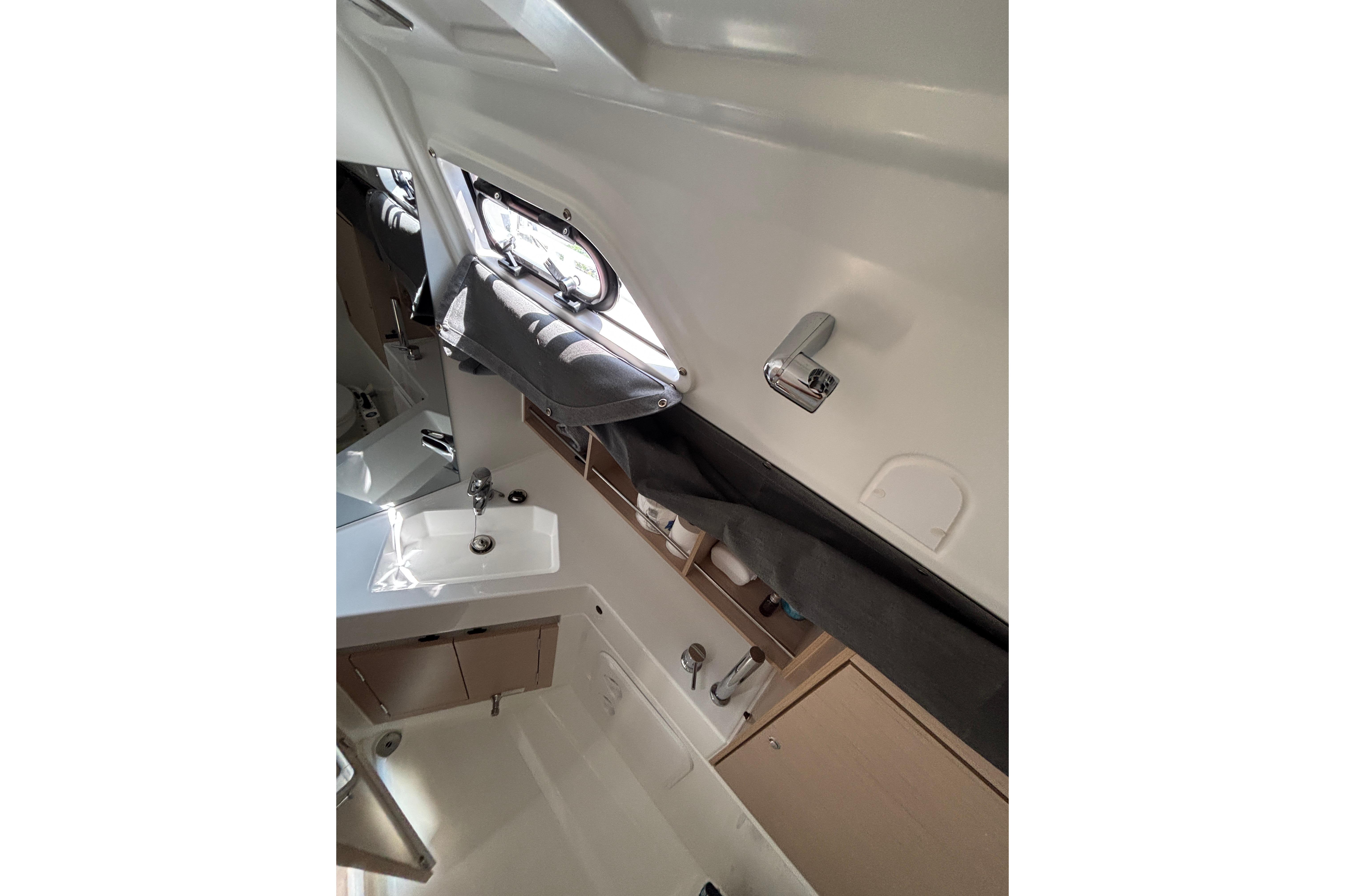 Interior of 2021 Beneteau Oceanis 30.1 yacht bathroom with sink and window.