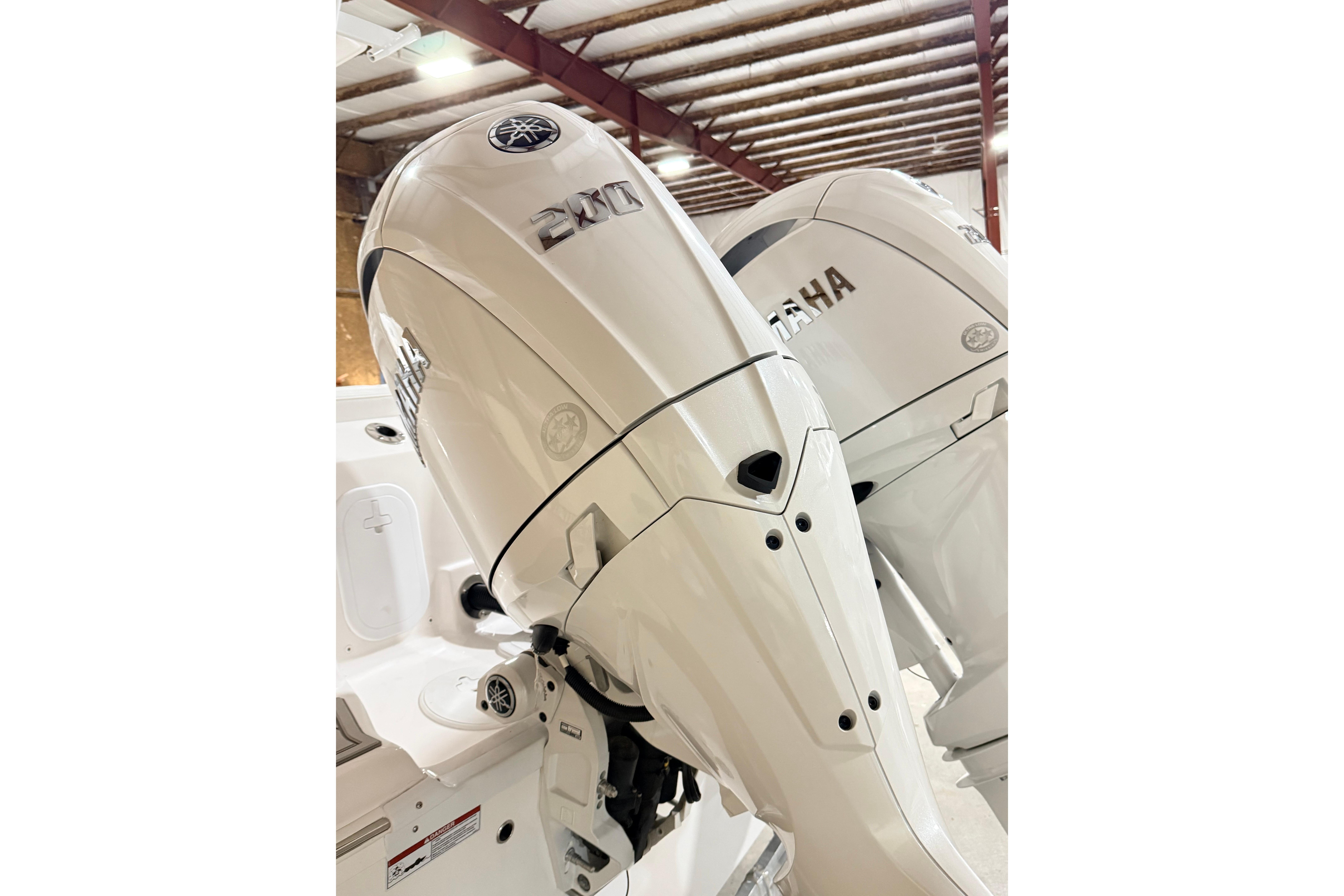 2026 Sea Fox 268 Commander with dual Yamaha 200 outboard engines in a boat storage facility.