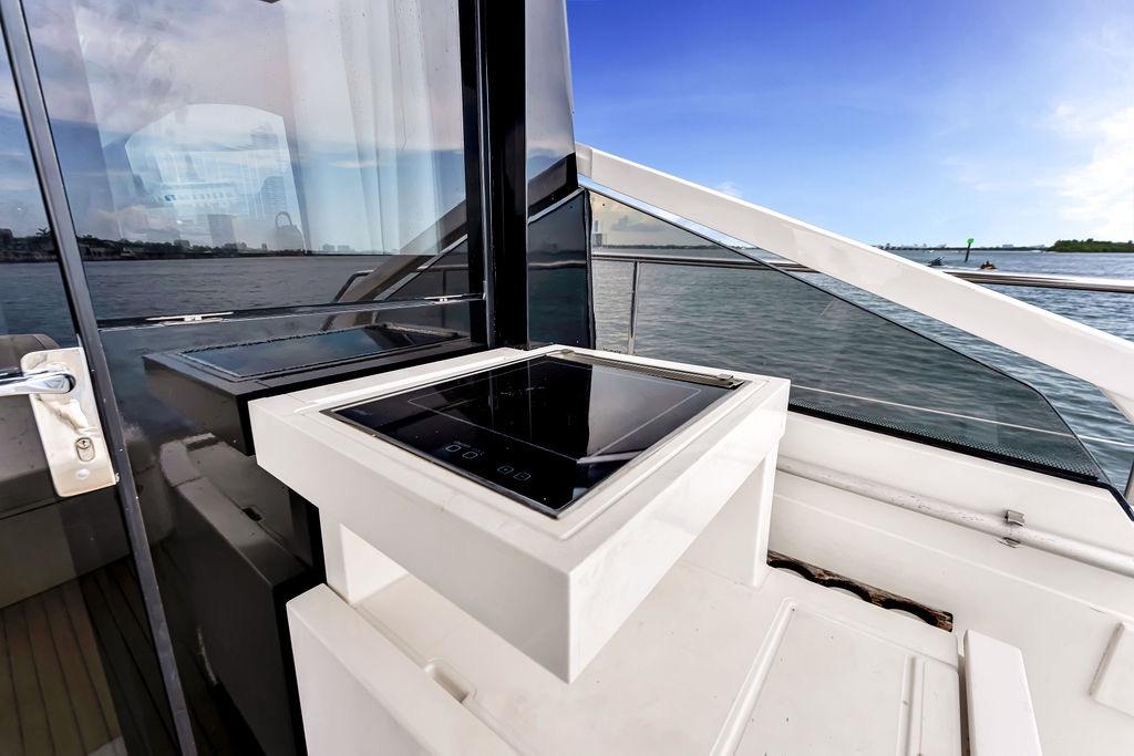 Fairline Targa 58 yacht deck with modern outdoor kitchen, overlooking serene waters, 2012 model.