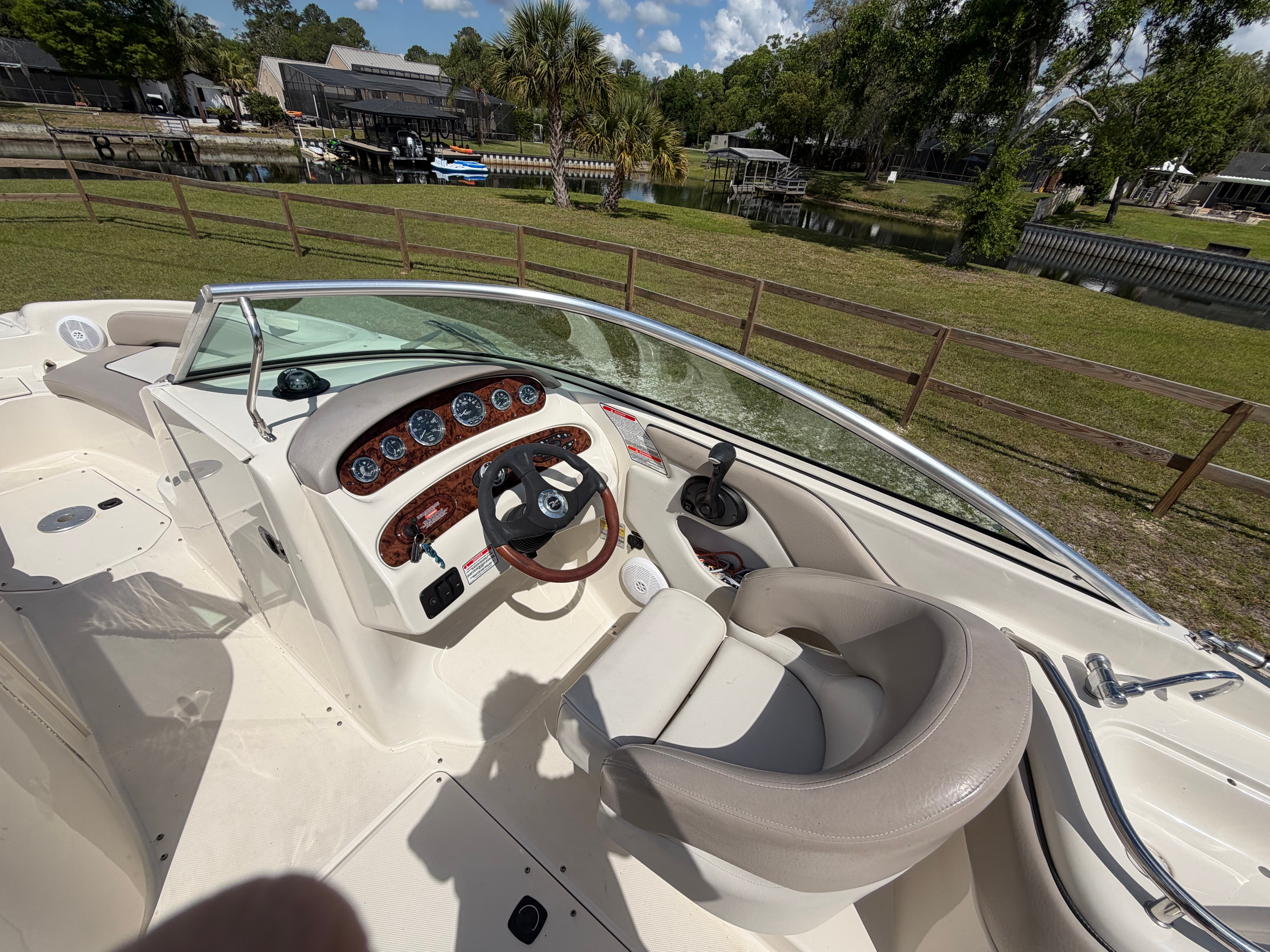The image shows the cockpit of a Sea Ray Bowrider with cream seats and a sleek dashboard.