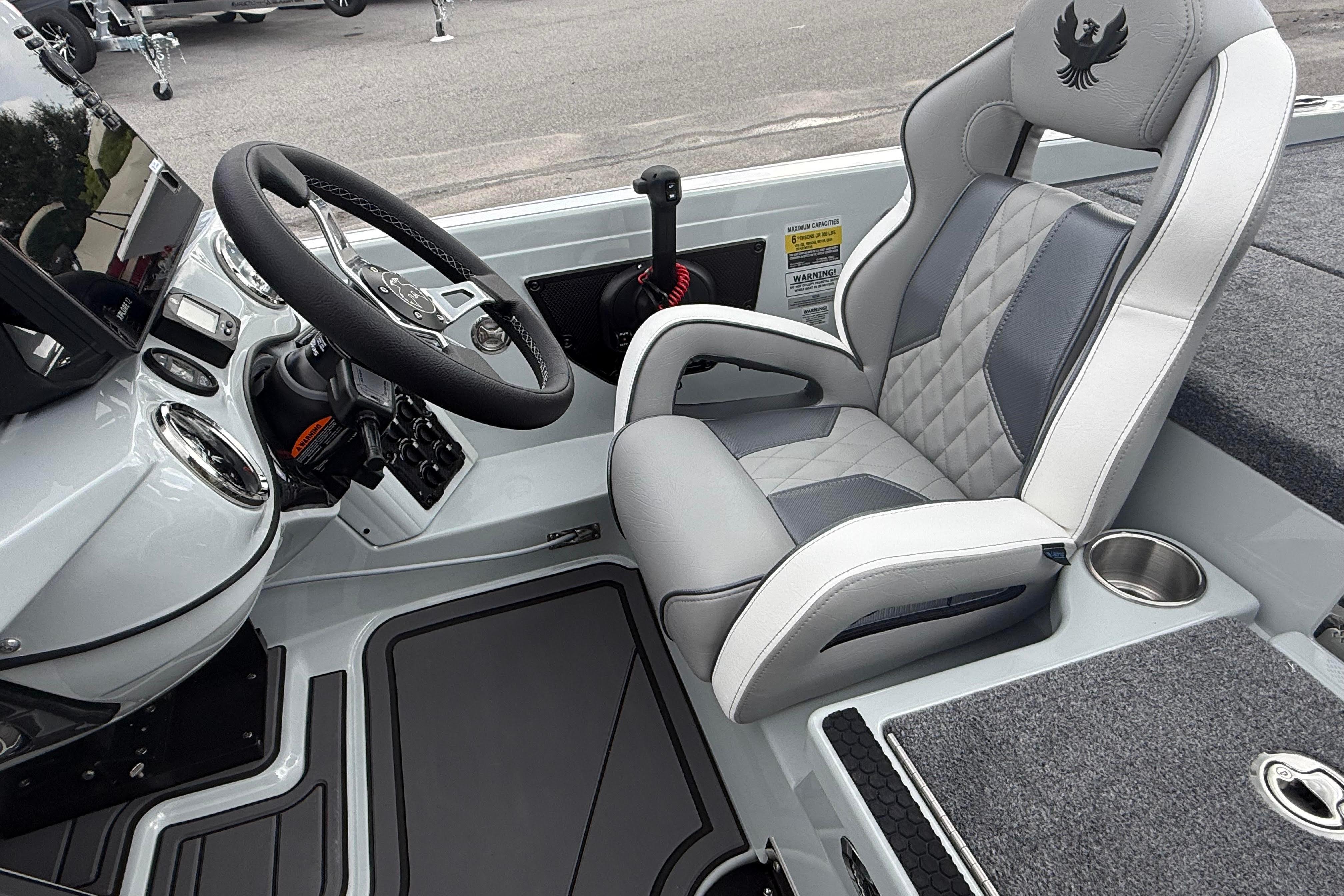 Interior of 2027 Phoenix 921 Elite X II boat with steering wheel and cushioned seat.