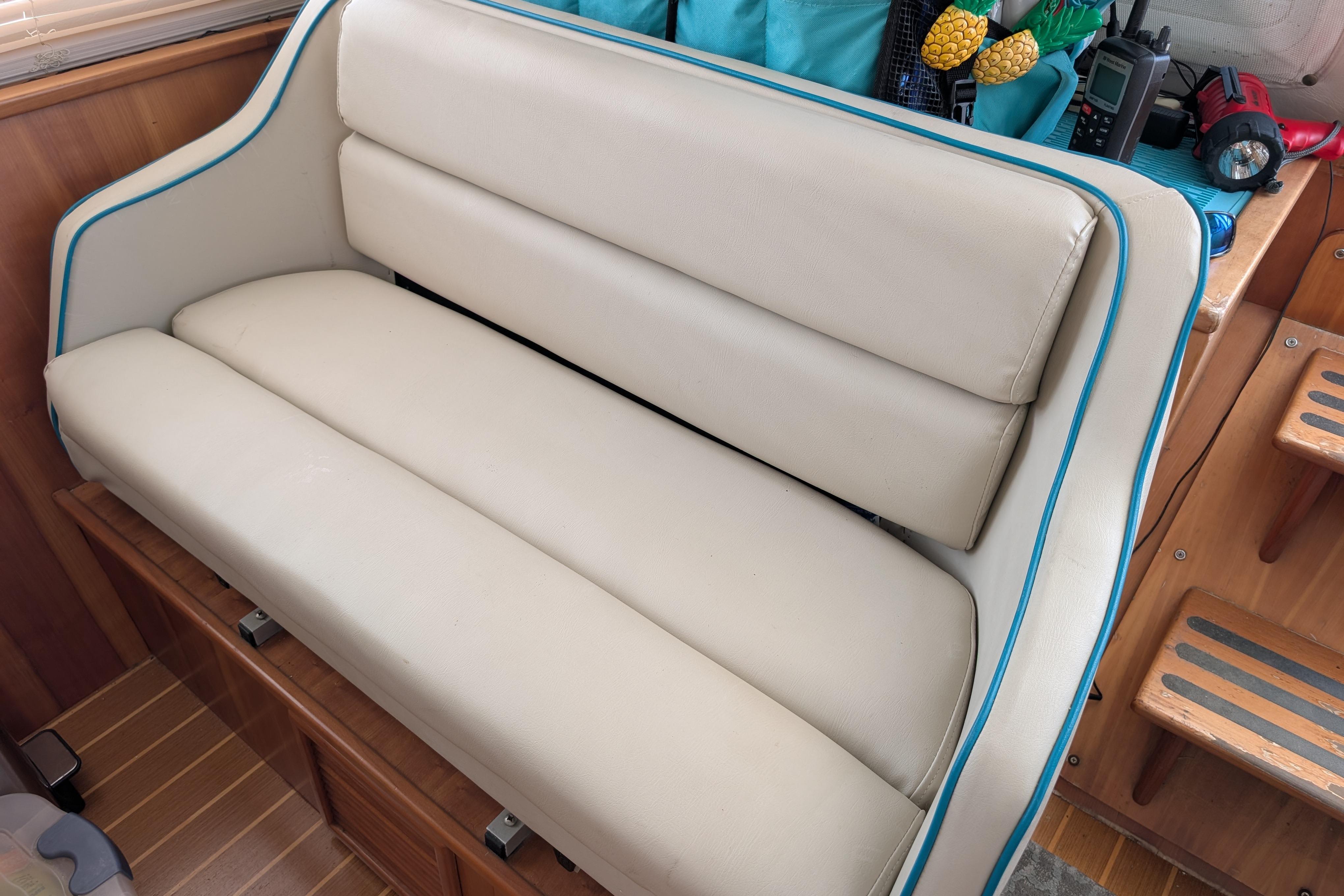 Cream-colored seating on 2004 PDQ 34 Powercat boat, with blue trim and wooden interior.